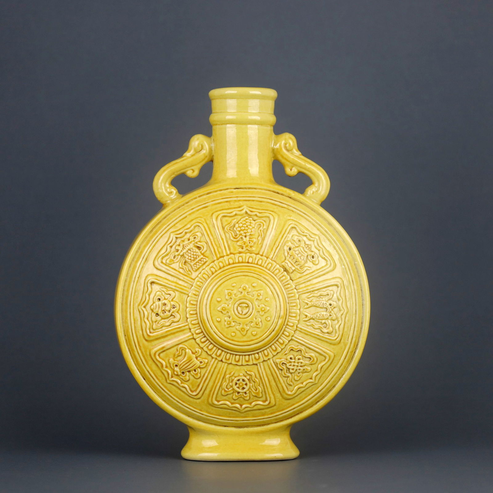 A YELLOW-GLAZED MOONFLASK CARVED WITH EIGHT TREASURES PATTERN: A YELLOW-GLAZED MOONFLASK CARVED WITH EIGHT TREASURES PATTERN H?21.8CM?D?15.3CM