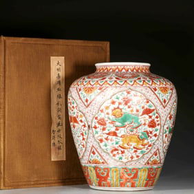 A RED-GREEN JAR WITH FLORAL PANELS