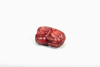 AN AMBER LION AND BALL CARVING