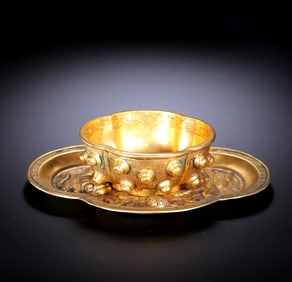 A GILT-BRONZE CUP AND SAUCER