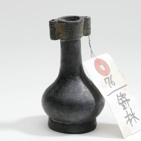 A BRONZE VASE WITH INTERLOCKING PATTERNS AND PENETRATING EARS