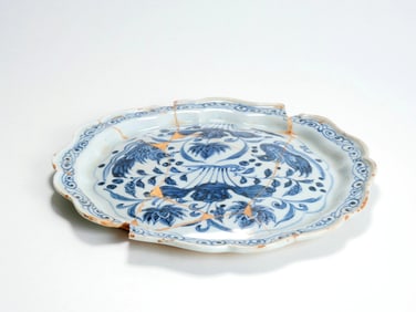 A YUAN BLUE-AND-WHITE PEACOCK AND FLOWER LOTUS-SHAPED DISH (RESTORED)