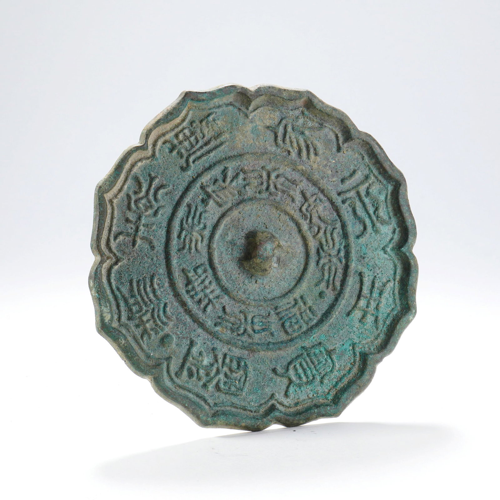 A BRONZE SUNFLOWER-SHAPED MIRROR WITH INSCRIPTION: A BRONZE SUNFLOWER-SHAPED MIRROR WITH INSCRIPTION D:14.5CM