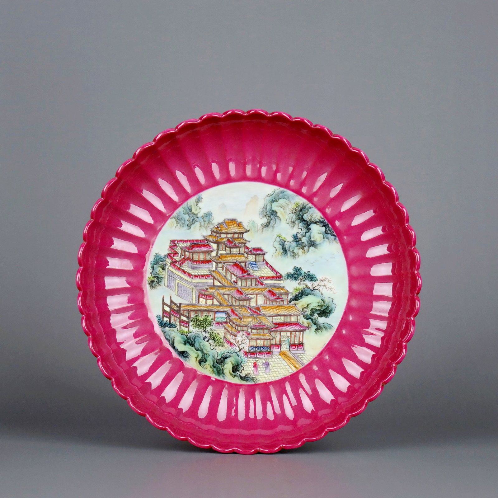 A ROUGE DE FER RED-GROUND FAMILLE ROSE CHRYSANTHEMUM-PETAL DISH WITH OPENWORK LANDSCAPE AND PAVILION: A ROUGE DE FER RED-GROUND FAMILLE ROSE CHRYSANTHEMUM-PETAL DISH WITH OPENWORK LANDSCAPE AND PAVILION H:3.4CM,D:18CM