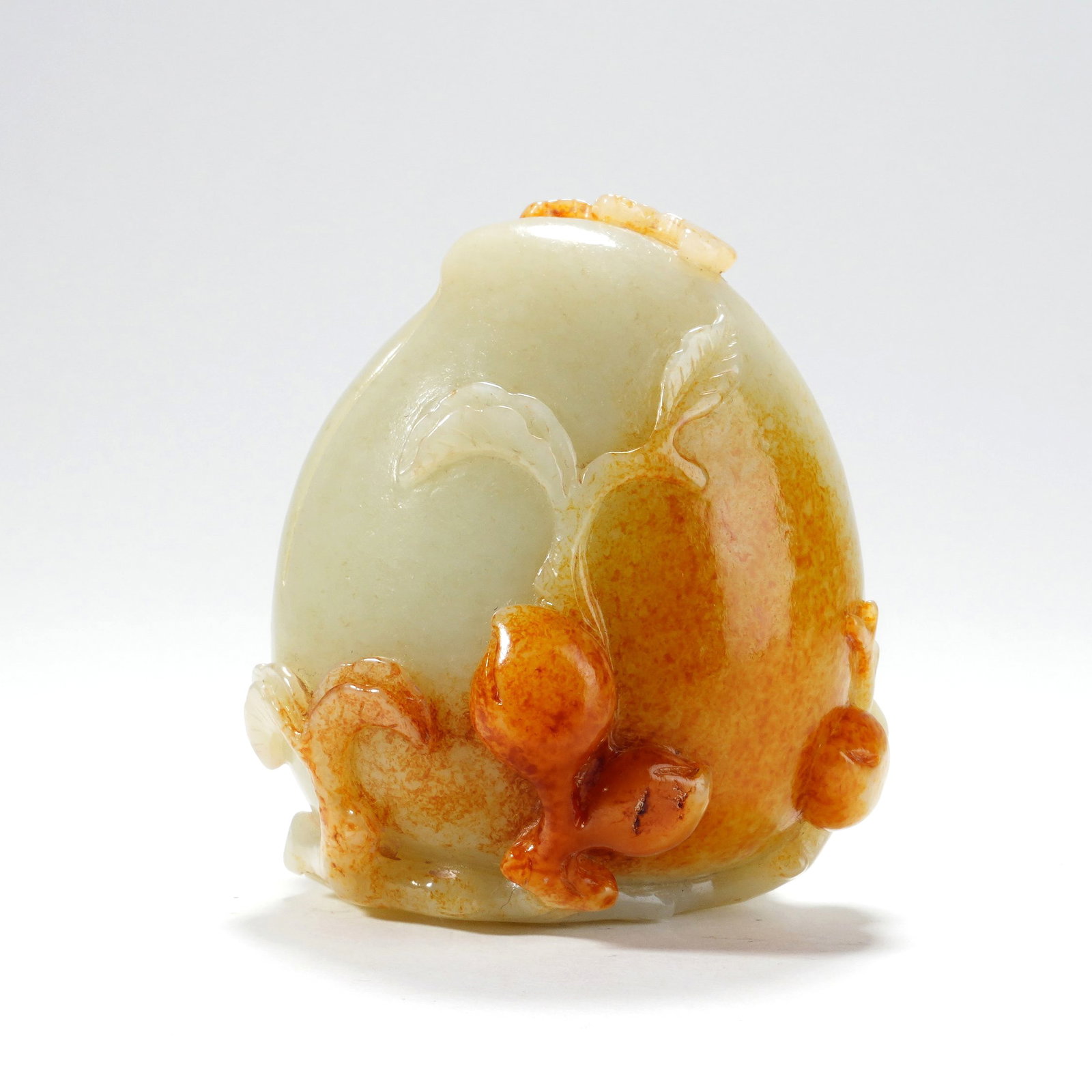 A HETIAN WHITE JADE ORNAMENT WITH SKIN CARVED LONGEVITY PEACH: A HETIAN WHITE JADE ORNAMENT WITH SKIN CARVED LONGEVITY PEACH H:7.5CM,W:5.5CM