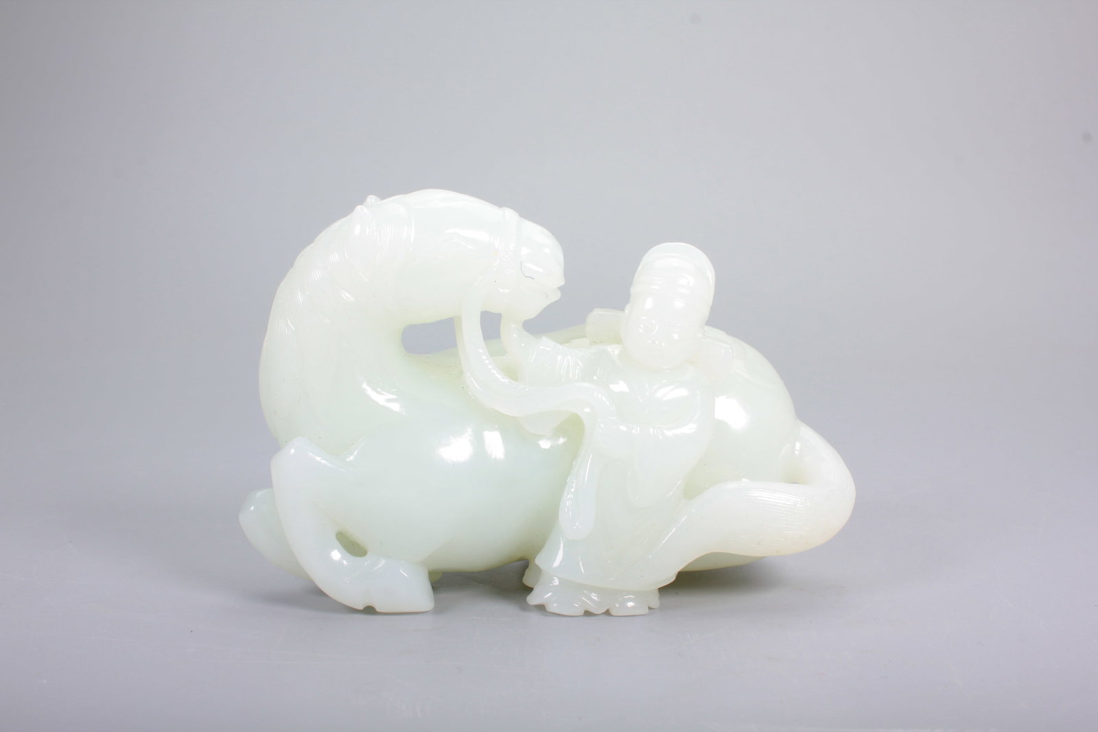 A HETIAN JADE ORNAMENT OF OFFICIAL LEADING HORSE: A HETIAN JADE ORNAMENT OF OFFICIAL LEADING HORSE H:7.5CM,L:11.2CM,W:5.8CM