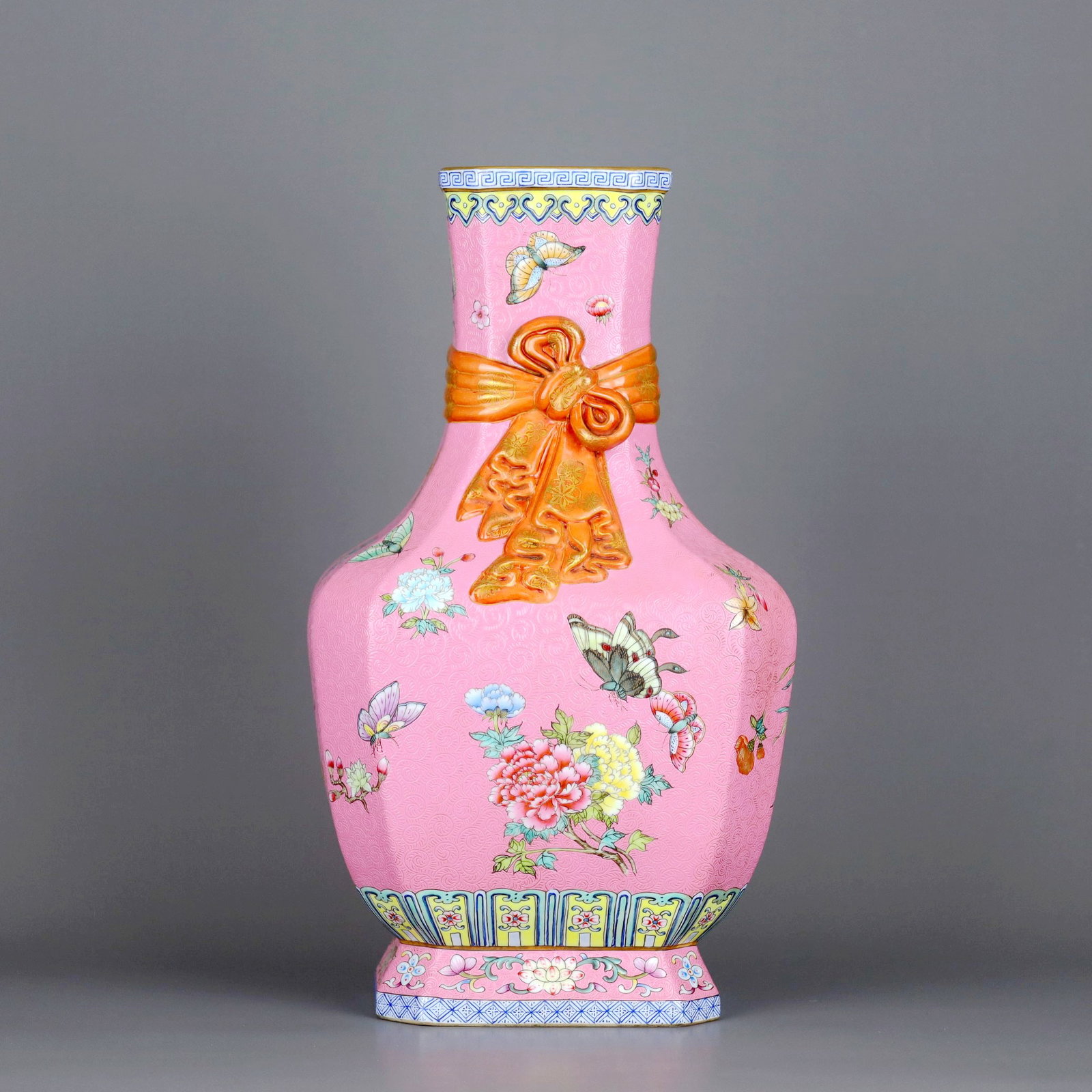 A PINK-GROUND ENAMELLED OCTAGONAL VASE WITH BUTTERFLY AND FLOWER PATTERNS AND RIBBON HANDLES: A PINK-GROUND ENAMELLED OCTAGONAL VASE WITH BUTTERFLY AND FLOWER PATTERNS AND RIBBON HANDLES H:35.5CM,D:20.3CM