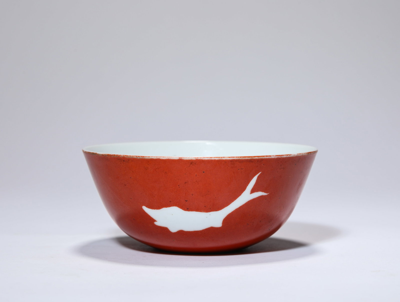 A RED-GLAZED ‘RESERVED FISH’ BOWL: A RED-GLAZED ‘RESERVED FISH’ BOWL Description: Dimensions: Width: 12 cm x Height: 5.1 cm. All measurements are approximate.