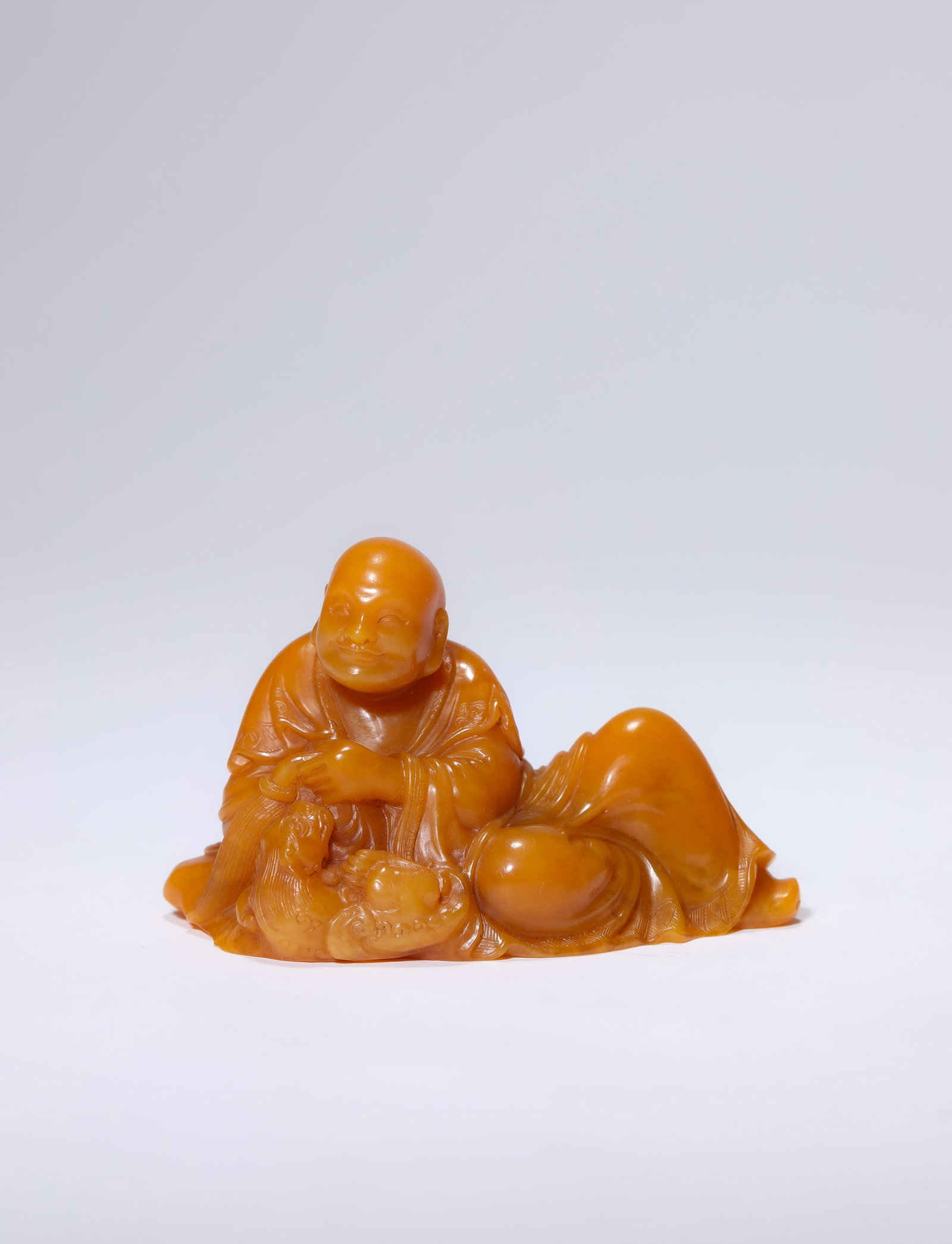 A TIANHUANG STONE FIGURE OF AN ARHAT: A TIANHUANG STONE FIGURE OF AN ARHAT Description: Dimensions: Length: 8.1 cm x Width: 3.9 cm x Height: 5 cm. All measurements are approximate.