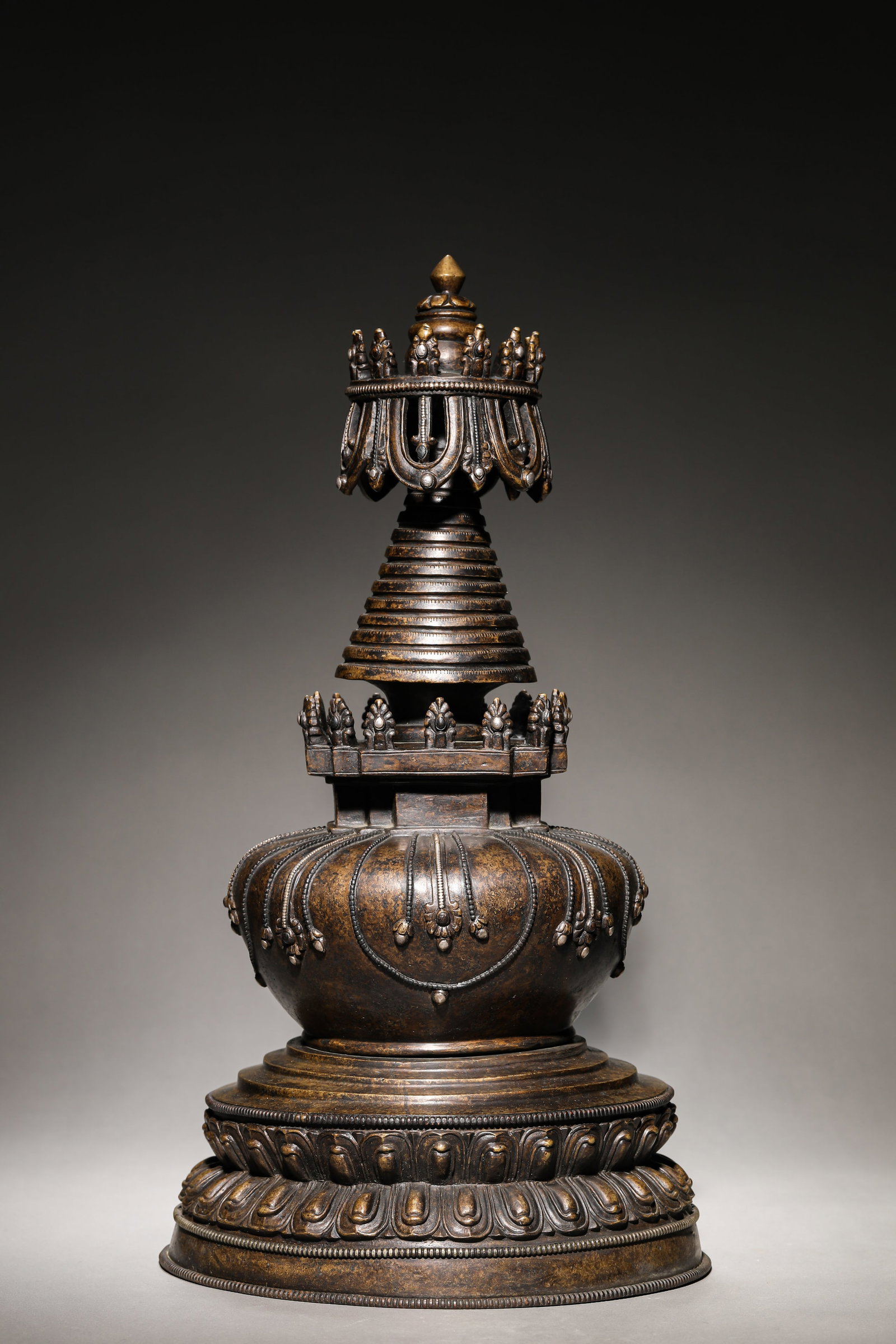 A TIBETAN KADAM-STYLE ALLOY BRONZE, SILVER AND COPPER-INLAID ‘HIGH-RANKING’ STUPA: A TIBETAN KADAM-STYLE ALLOY BRONZE, SILVER AND COPPER-INLAID ‘HIGH-RANKING’ STUPA Description: Dimensions: Weight: 9150 g. Width: 24.3 cm x Height: 46 cm. All measurements are approximate.