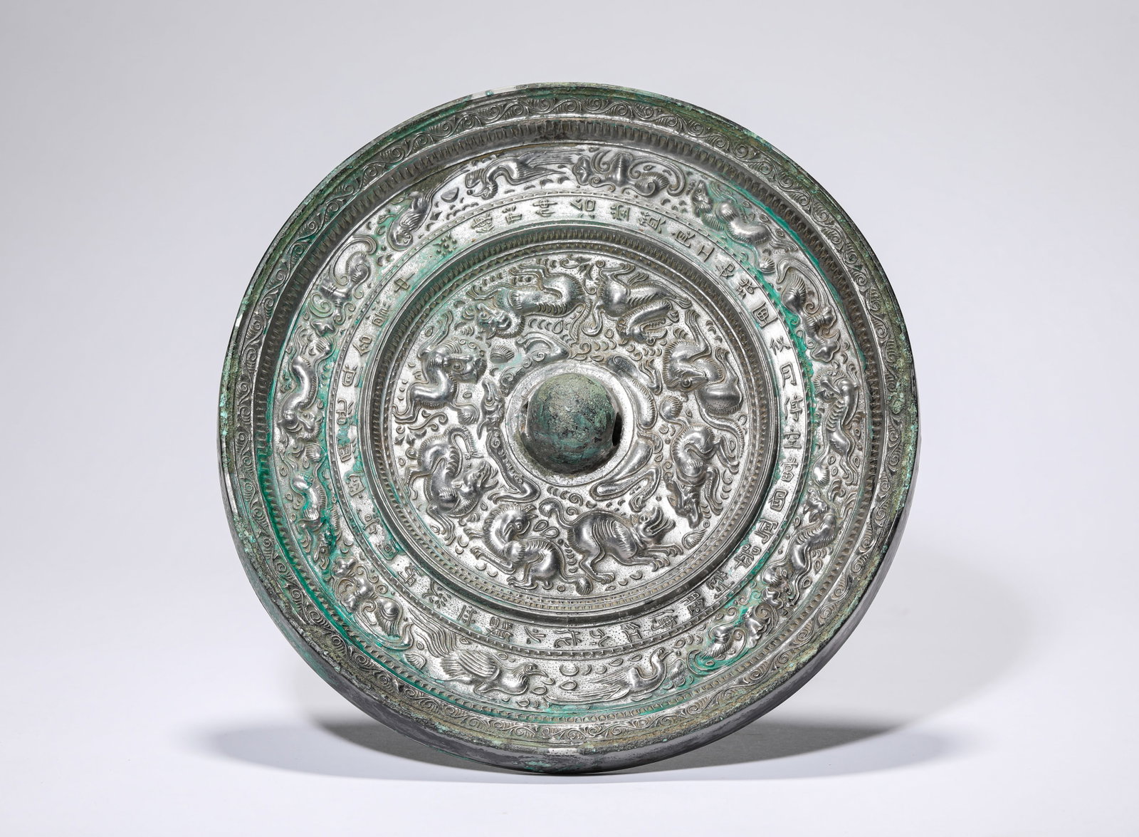 A BRONZE MIRROR: A BRONZE MIRROR Description: Dimensions: Weight: 2252 g. Width: 22.6 cm. All measurements are approximate.