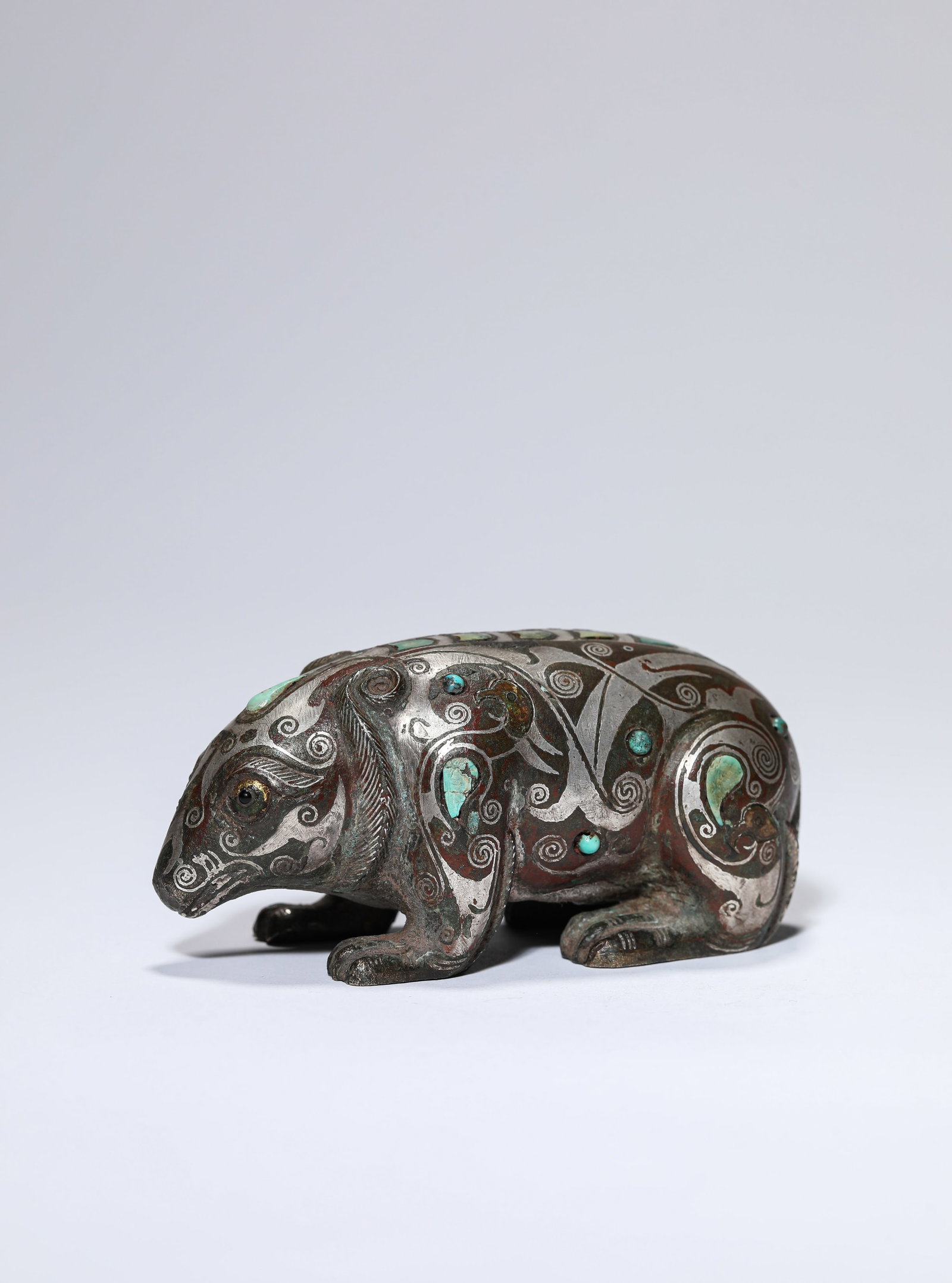 A SILVER AND TURQUOISE-INLAID BRONZE BEAR: A SILVER AND TURQUOISE-INLAID BRONZE BEAR Description: Dimensions: Weight: 209 g. Length: 9.1 cm x Width: 4 cm x Height: 4.2 cm. All measurements are approximate.