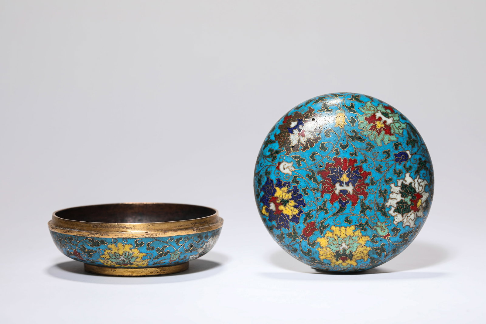 A CLOISONNé ENAMEL ‘INTERLOCKING LOTUS’ COVERED BOX: A CLOISONNé ENAMEL ‘INTERLOCKING LOTUS’ COVERED BOX Description: Dimensions: Weight: 276 g. Width: 8.9 cm x Height: 4.6 cm. All measurements are approximate.