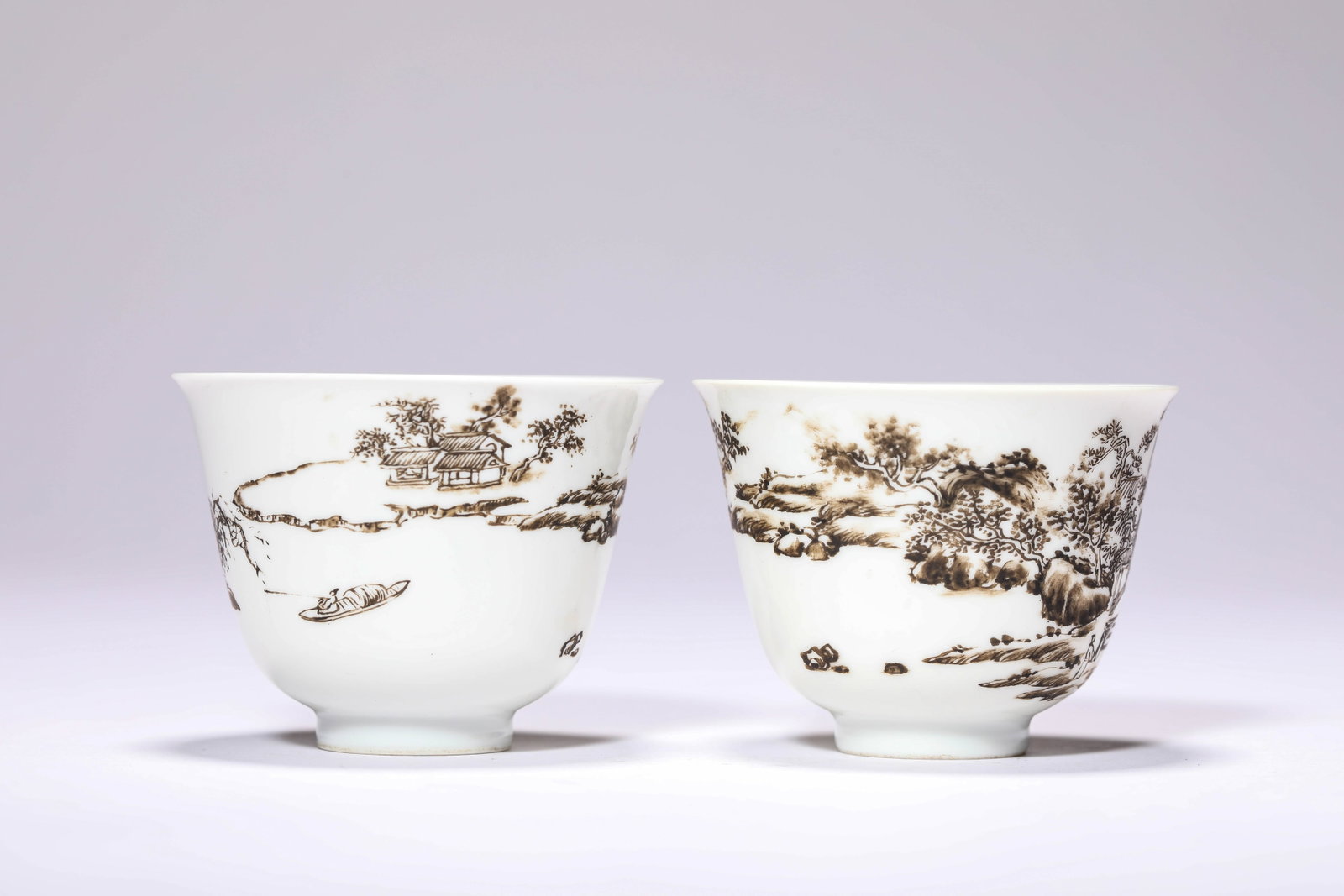 A PAIR OF BLACK-DECORATED 'LANDSCAPE AND FIGURES' CUPS: A PAIR OF BLACK-DECORATED 'LANDSCAPE AND FIGURES' CUPS Description: Dimensions: Width: 6.7 cm x Height: 5 cm. All measurements are approximate.