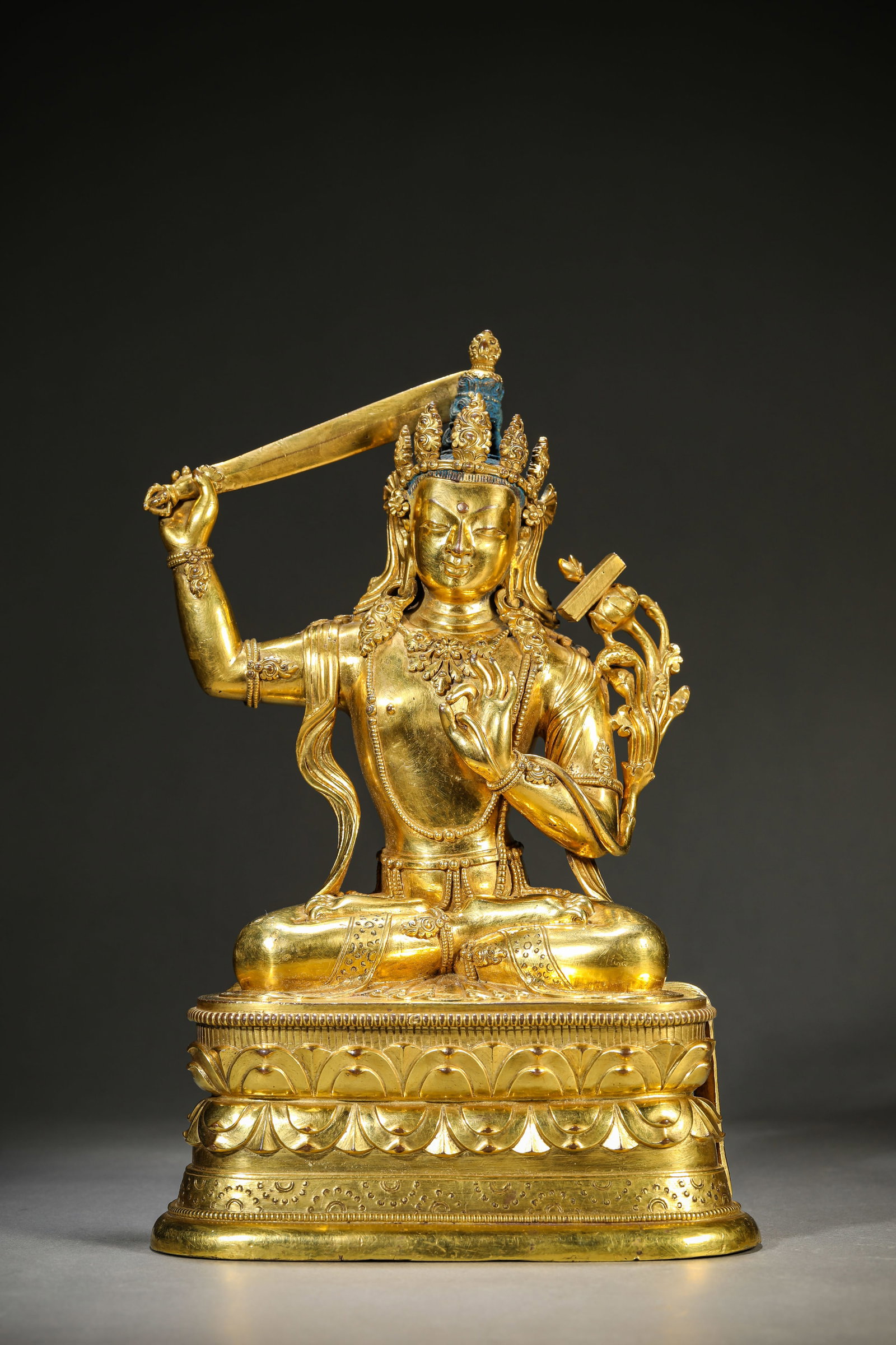 A GILT-BRONZE FIGURE OF MANJUSHRI: A GILT-BRONZE FIGURE OF MANJUSHRI Description: Dimensions: Weight: 3653 g. Length: 18.6 cm x Width: 12.2 cm x Height: 28.7 cm. All measurements are approximate.