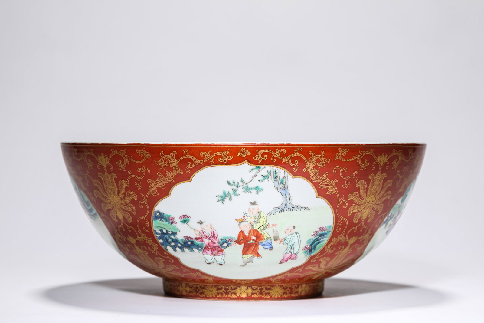 A CORAL-RED-GROUND GILT-DECORATED ‘FIGURAL RESERVES’ BOWL: A CORAL-RED-GROUND GILT-DECORATED ‘FIGURAL RESERVES’ BOWL Description: Dimensions: Width: 31.9 cm x Height: 13 cm. All measurements are approximate.