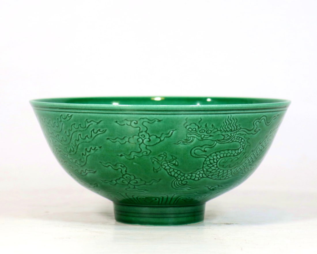 A MELON GREEN GLAZE CARVED DRAGON AND PHOENIX BOWL: A MELON GREEN GLAZE CARVED DRAGON AND PHOENIX BOWL D:15.6CM,H:7.2CM