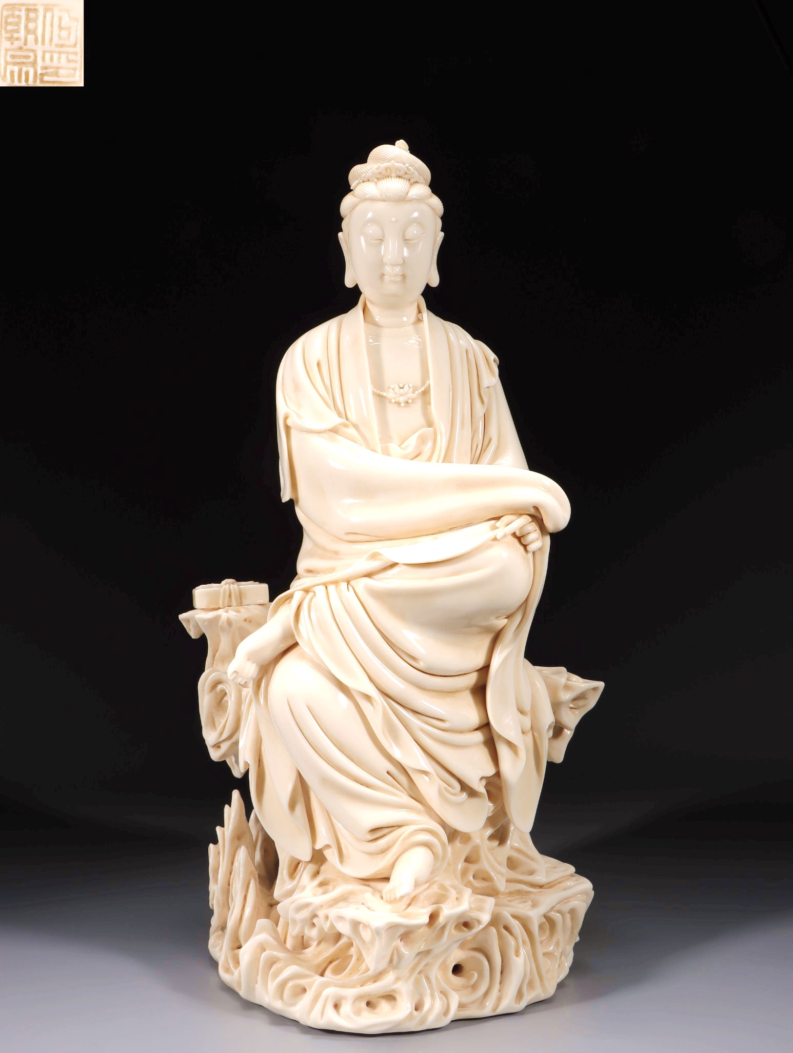 A DEHUA WHITE PORCELAIN CHILAIHONG SUTRA-KEEPING SEATED GUANYIN FIGURE WITH HE CHAOZHONG MARK: A DEHUA WHITE PORCELAIN CHILAIHONG SUTRA-KEEPING SEATED GUANYIN FIGURE WITH HE CHAOZHONG MARK H:45CM,L:24CM,W:16CM