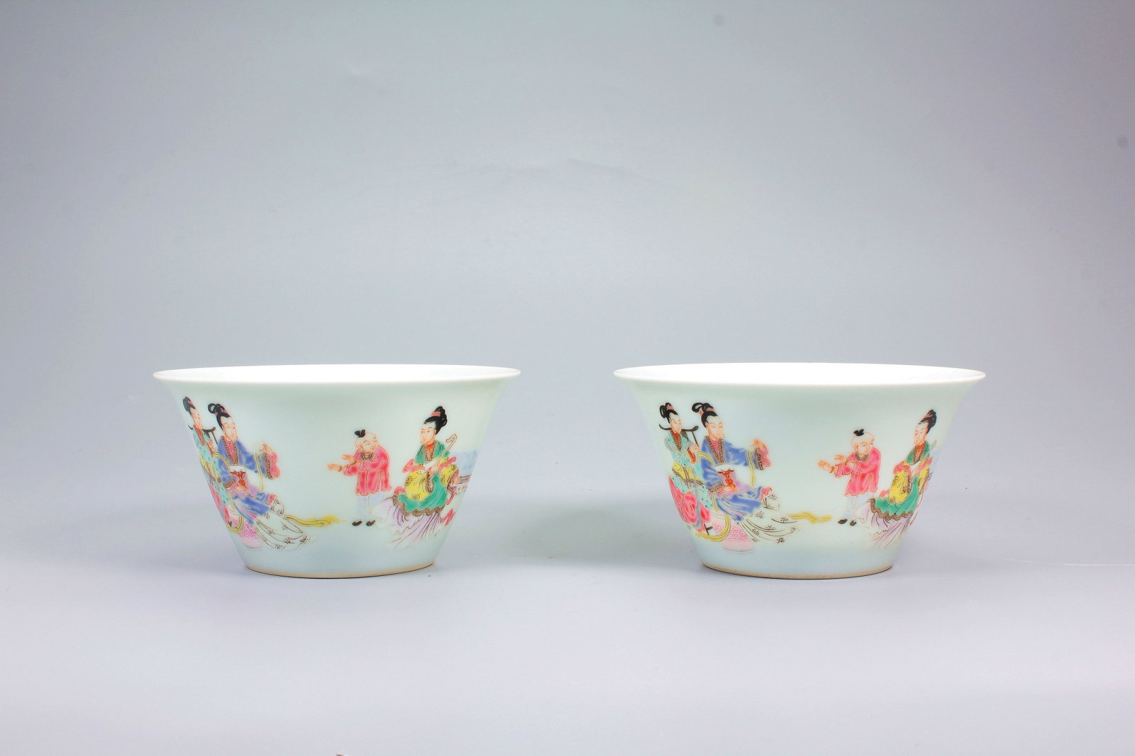 A PAIR OF FAMILLE ROSE THREE LADIES TEACHING THE SON HORSESHOE CUPS: A PAIR OF FAMILLE ROSE THREE LADIES TEACHING THE SON HORSESHOE CUPS H:5.4CM,D:9.8CM