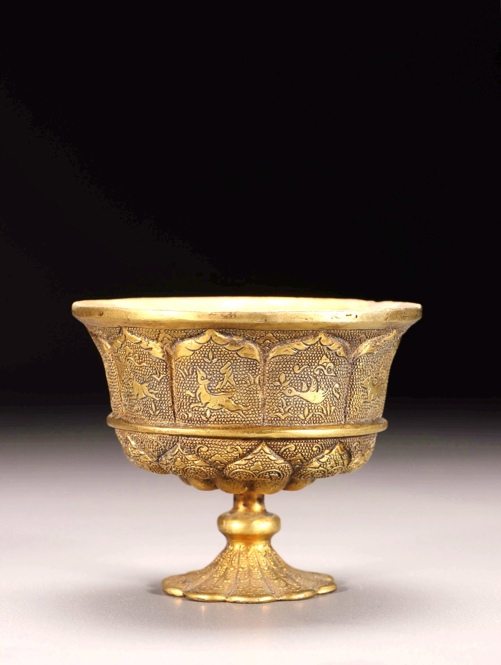 A GILT BRONZE CHASED HIGH STEM CUP