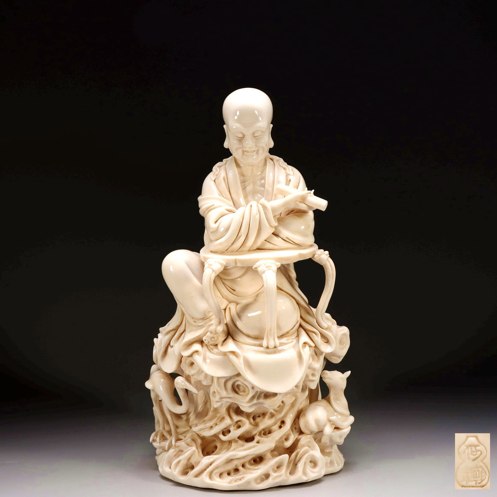 A DEHUA WHITE PORCELAIN SKINNY BONE LUOHAN SEATED FIGURE WITH HE CHAOZHONG MARK: A DEHUA WHITE PORCELAIN SKINNY BONE LUOHAN SEATED FIGURE WITH HE CHAOZHONG MARK H:38.5CM,L:21CM,W:16CM