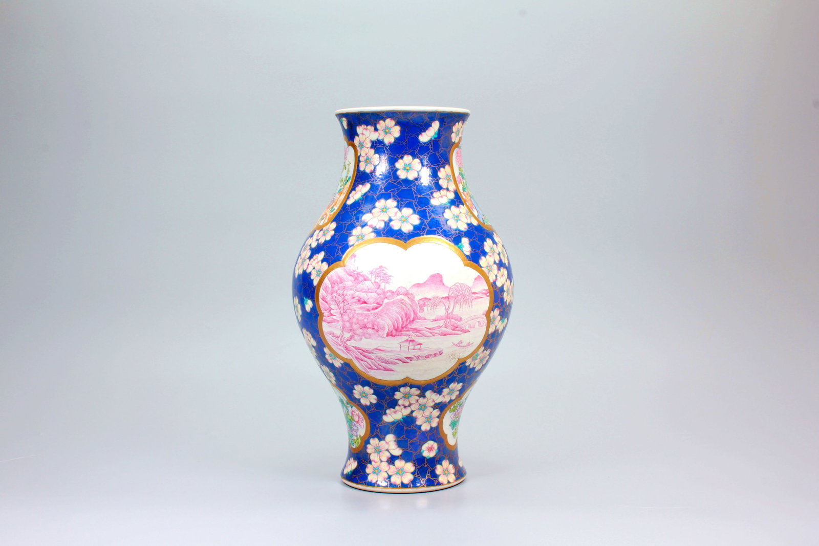 A BLUE GROUND FAMILLE ROSE PRUNUS SNOWFLAKE OPENWORK LANDSCAPE OLIVE VASE: A BLUE GROUND FAMILLE ROSE PRUNUS SNOWFLAKE OPENWORK LANDSCAPE OLIVE VASE H:28CM,D:17CM