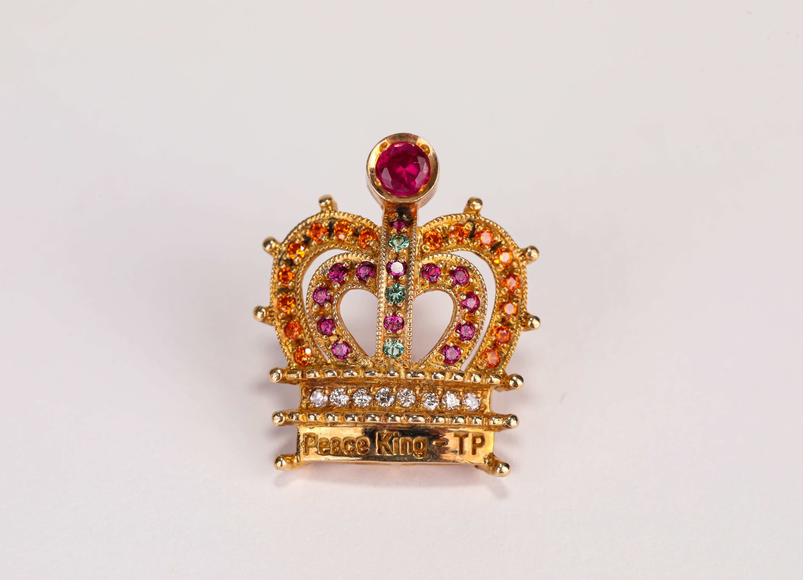 A Gold and Gemstone Brooch: Dimensions: Weight: 4 g. Width: 1.9 cm x Height: 2.2 cm. All measurements are approximate.