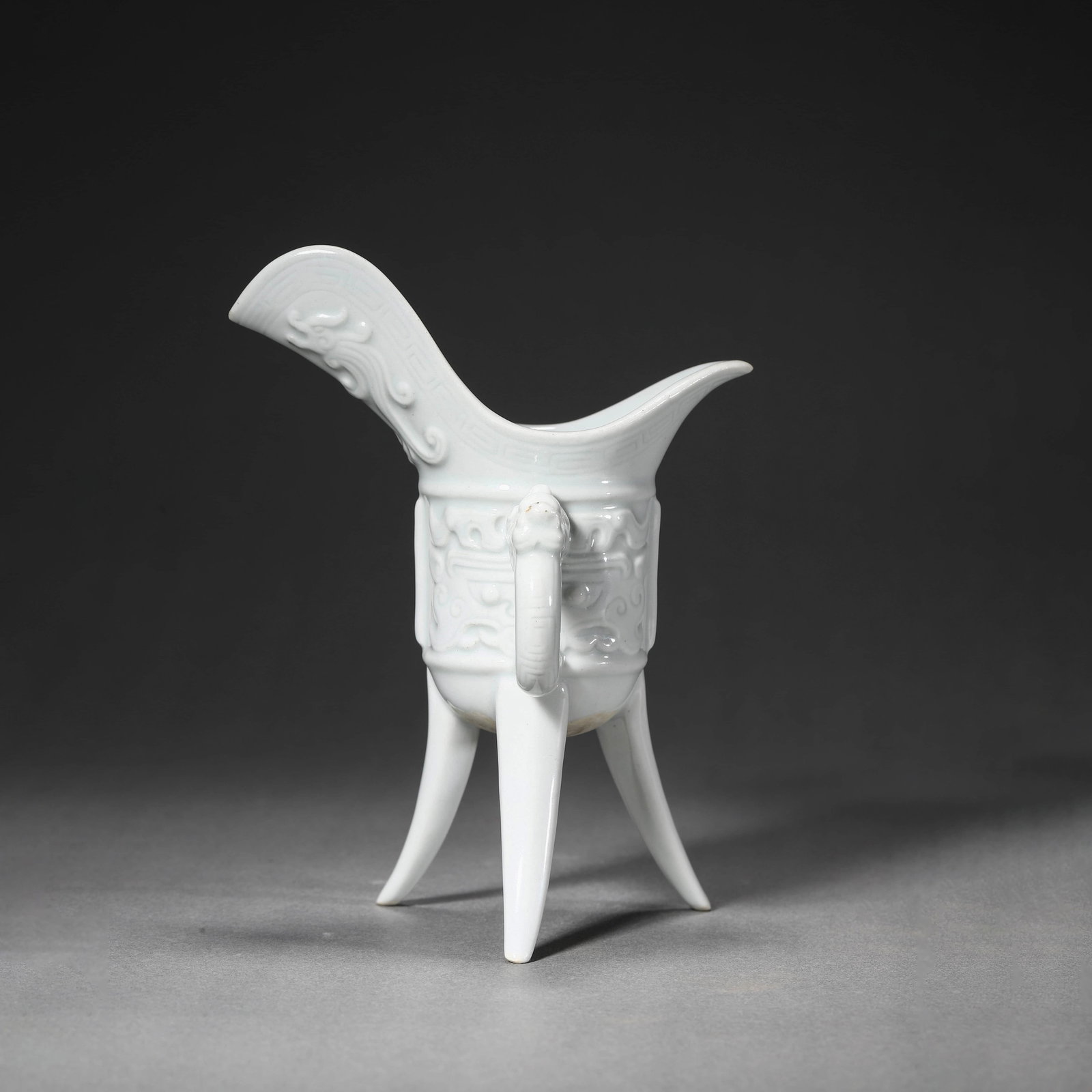 White-Glazed Beast-Face Wine Vessel: White-Glazed Beast-Face Wine Vessel Length:10.5cm, Width:7.5cm, Height:14cm,