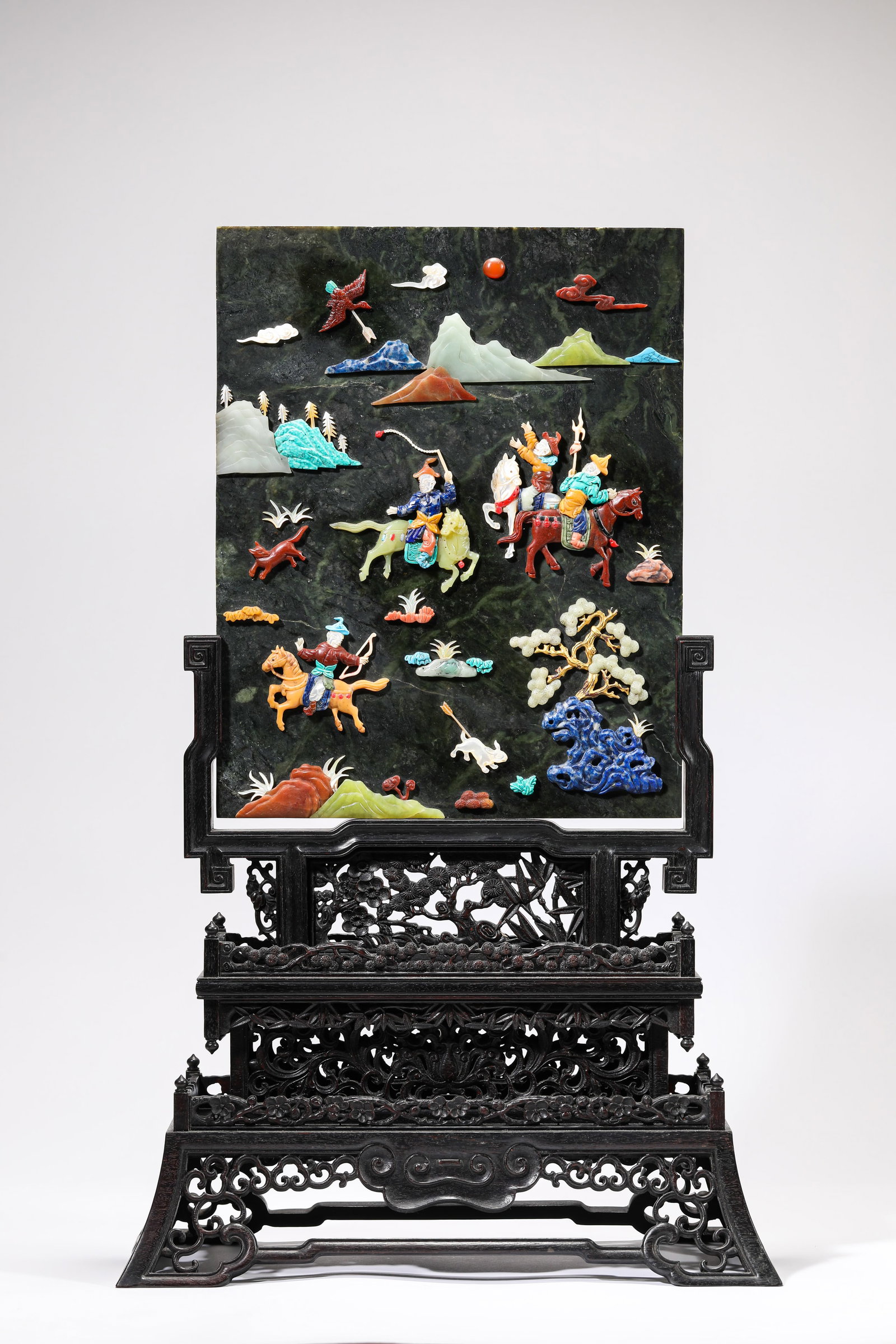 A ZITAN STAND, SPINACH JADE AND ?HUNDRED TREASURES?-INLAID ?HUNTING SCENE? TABLE SCREEN: A SPINACH JADE AND ?HUNDRED TREASURES?-INLAID ?HUNTING SCENE? TABLE SCREEN Description: Dimensions: Length: 35 cm x Width: 16.8 cm x Height: 56 cm. All measurements are approximate.