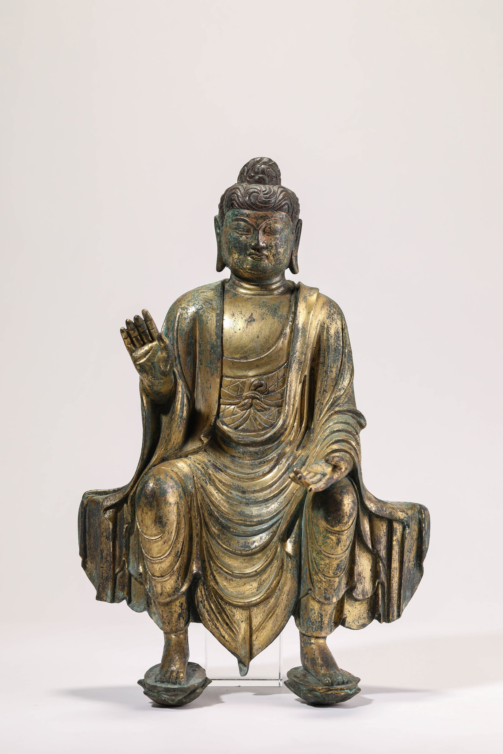 A GILT-BRONZE SEATED FIGURE OF AVALOKITESHVARA: A GILT-BRONZE SEATED FIGURE OF AVALOKITESHVARA Description: Dimensions: Weight: 4650 g. Length: 22.2 cm x Width: 13.5 cm x Height: 35.5 cm. All measurements are approximate.