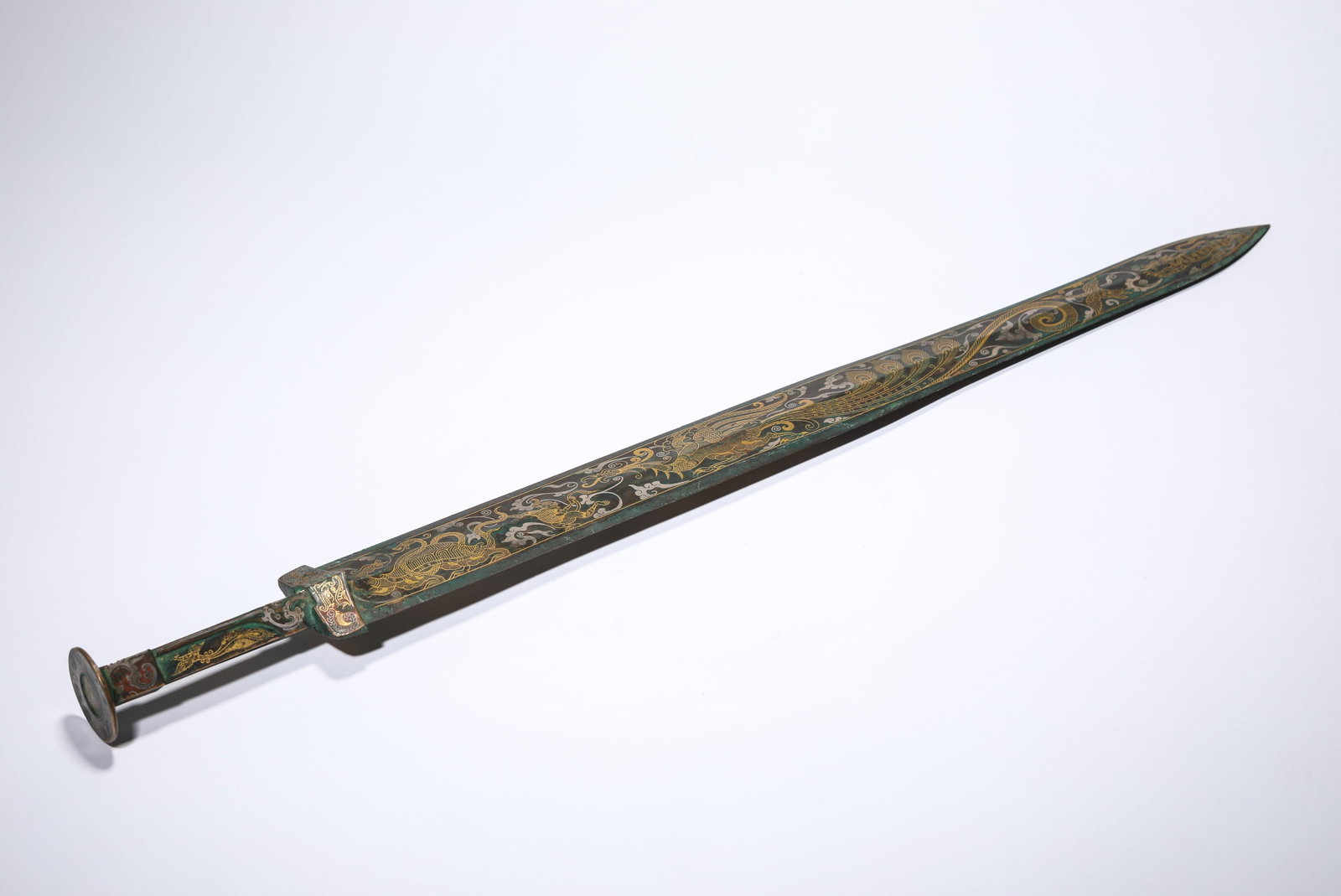 A GOLD AND SILVER-INLAID BRONZE SWORD: A GOLD AND SILVER-INLAID BRONZE SWORD Description: Dimensions: Weight: 954 g. Width: 5.3 cm x Height: 60 cm. All measurements are approximate.