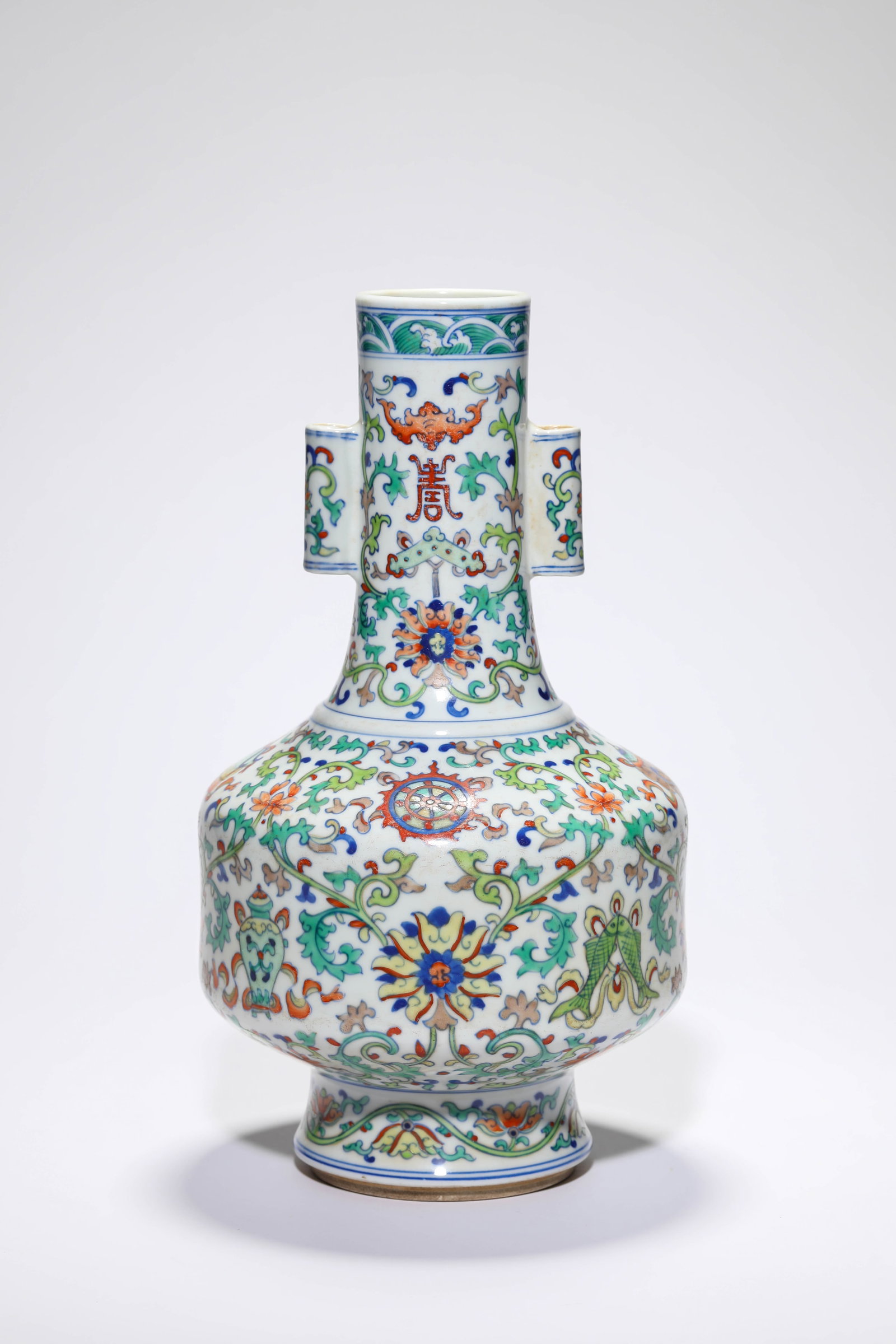 A DOUCAI ?INTERLOCKING FLORALS AND EIGHT BUDDHIST EMBLEMS? VASE WITH ?TUBE HANDLES? (1 of 4)