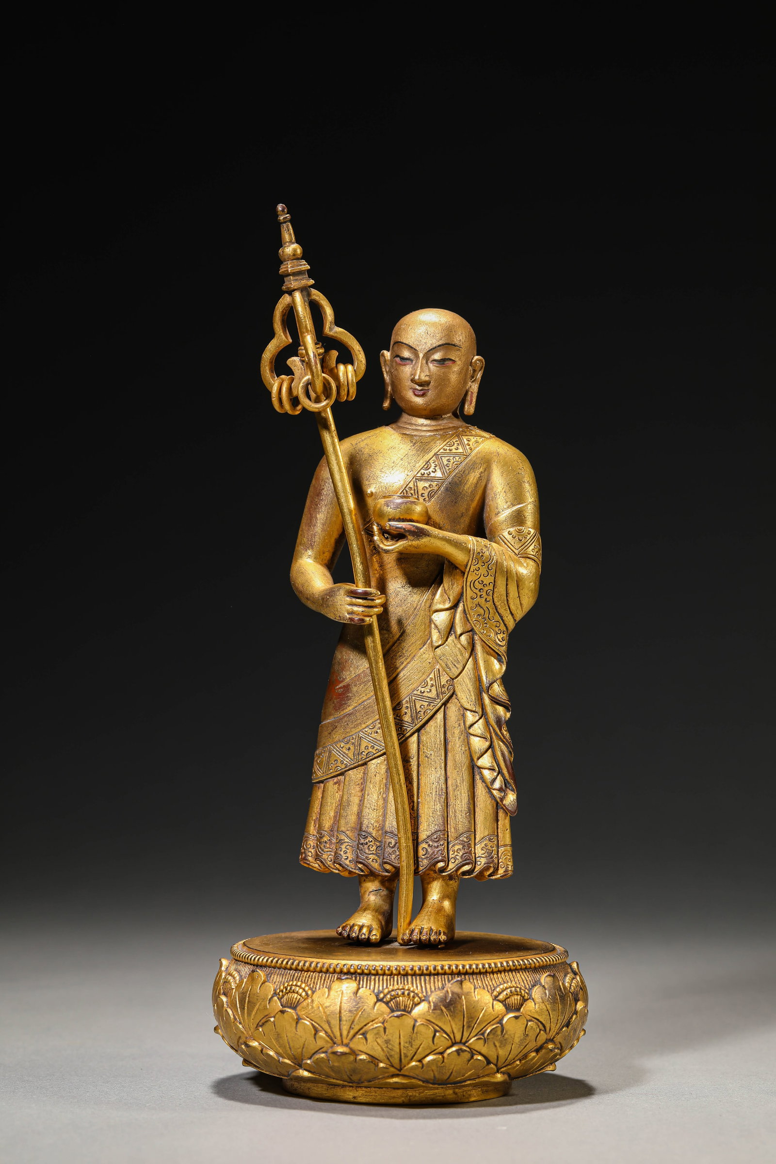 A GILT-BRONZE FIGURE OF KSITIGARBHA: A GILT-BRONZE FIGURE OF KSITIGARBHA Description: Dimensions: Weight: 1200 g. Width: 9.5 cm x Height: 23 cm. All measurements are approximate.