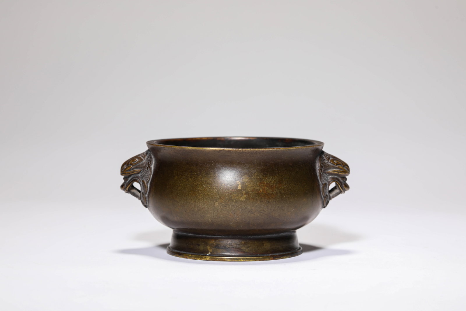 A BRONZE ?BEAST-HEAD HANDLES? CENSER: A BRONZE ?BEAST-HEAD HANDLES? CENSER Description: Dimensions: Weight: 563 g. Length: 13 cm x Width: 10.2 cm x Height: 6.3 cm. All measurements are approximate.