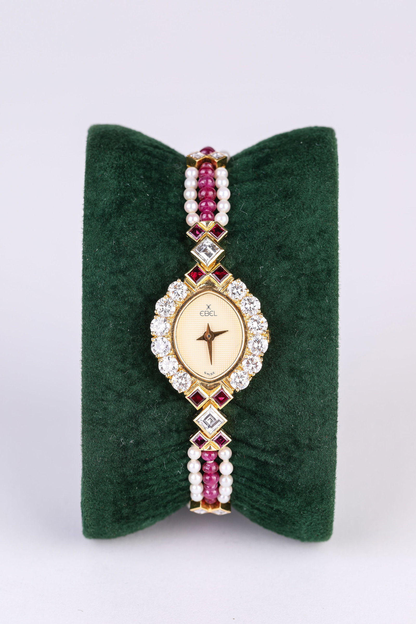 AN EBEL GEMSTONE AND GOLD WRISTWATCH: AN EBEL GEMSTONE AND GOLD WRISTWATCH Description: Dimensions: Width: 21 mm x Height: 25 mm. All measurements are approximate.