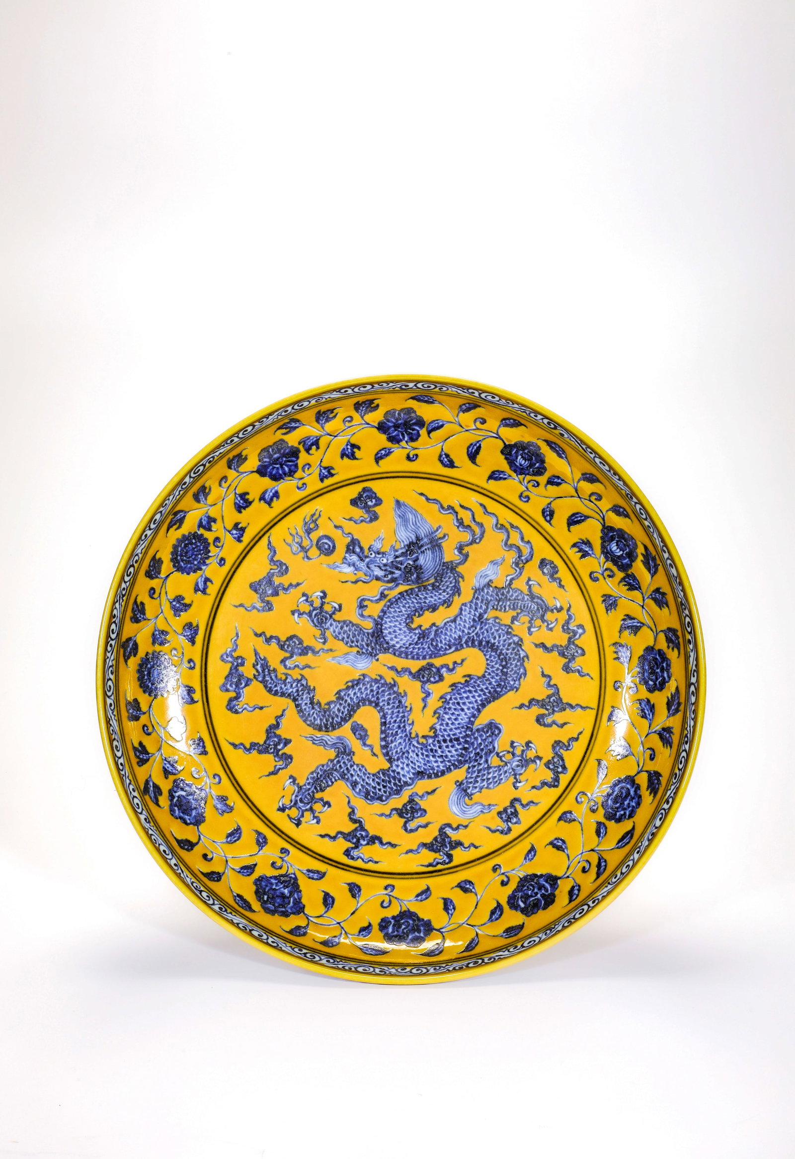 A YELLOW-GROUND BLUE AND WHITE DRAGON CLOUD DISH: A YELLOW-GROUND BLUE AND WHITE DRAGON CLOUD DISH Size:Width:34cm,Height:6cm