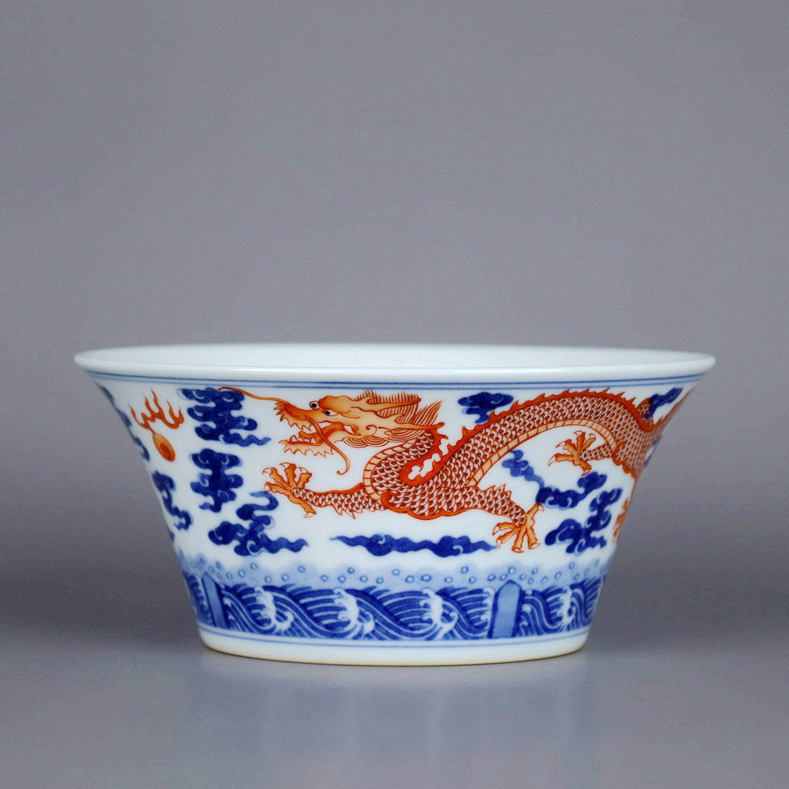 A BLUE AND WHITE IRON-RED DRAGON AND CLOUD HORSESHOOT CUP: A BLUE AND WHITE IRON-RED DRAGON AND CLOUD HORSESHOOT CUP Size:Height:7cm,Diam:15.5cm