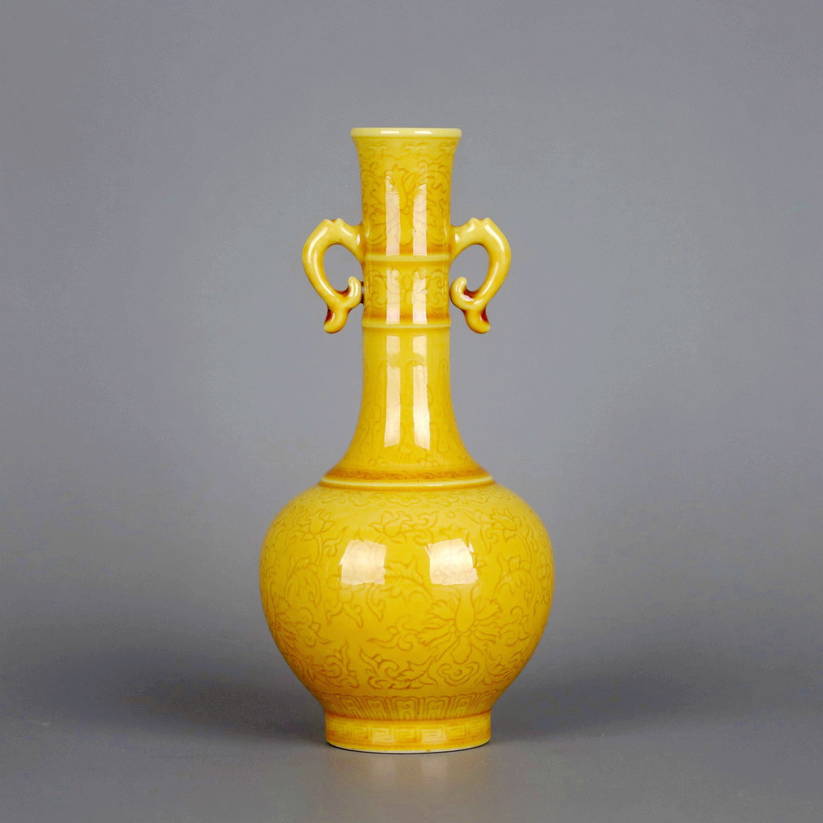 A YELLOW GLAZED ANHUA LOTUS DOUBLE-EAR VASE: A YELLOW GLAZED ANHUA LOTUS DOUBLE-EAR VASE Size:Height:12.2cm,Diam:5.7cm