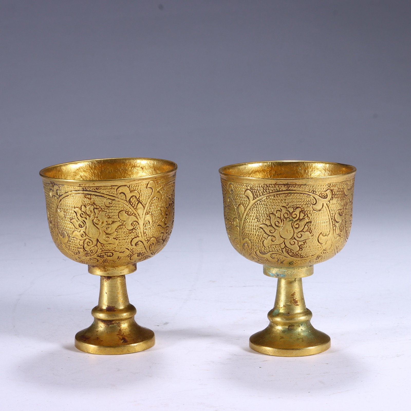 A PAIR OF CHINESE GILT-BRONZE STEM CUPS WITH FLORAL ENGRAVING: A PAIR OF CHINESE GILT-BRONZE STEM CUPS WITH FLORAL ENGRAVING (6.8 x 5.2cm)
