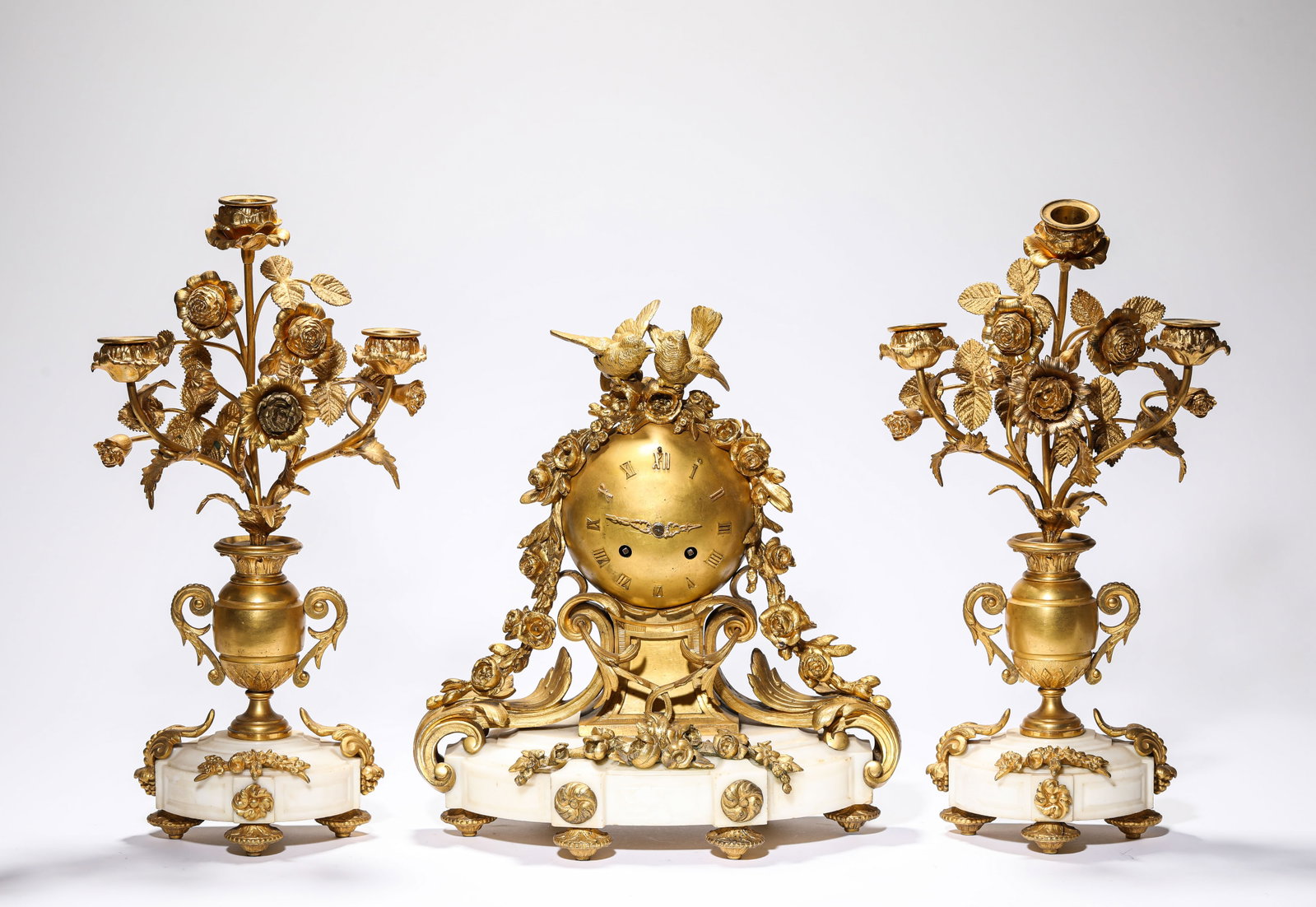 A GROUP OF GILT-BRONZE AND WHITE MARBLE MANTEL CLOCK AND FLOWER HOLDERS: A GROUP OF GILT-BRONZE AND WHITE MARBLE MANTEL CLOCK AND FLOWER HOLDERS Description: Dimensions: Weight: 7050 g. Length: 29 cm x Width: 13 cm x Height: 31.6 cm. Weight: 5200 g. Length: 20.2 cm x