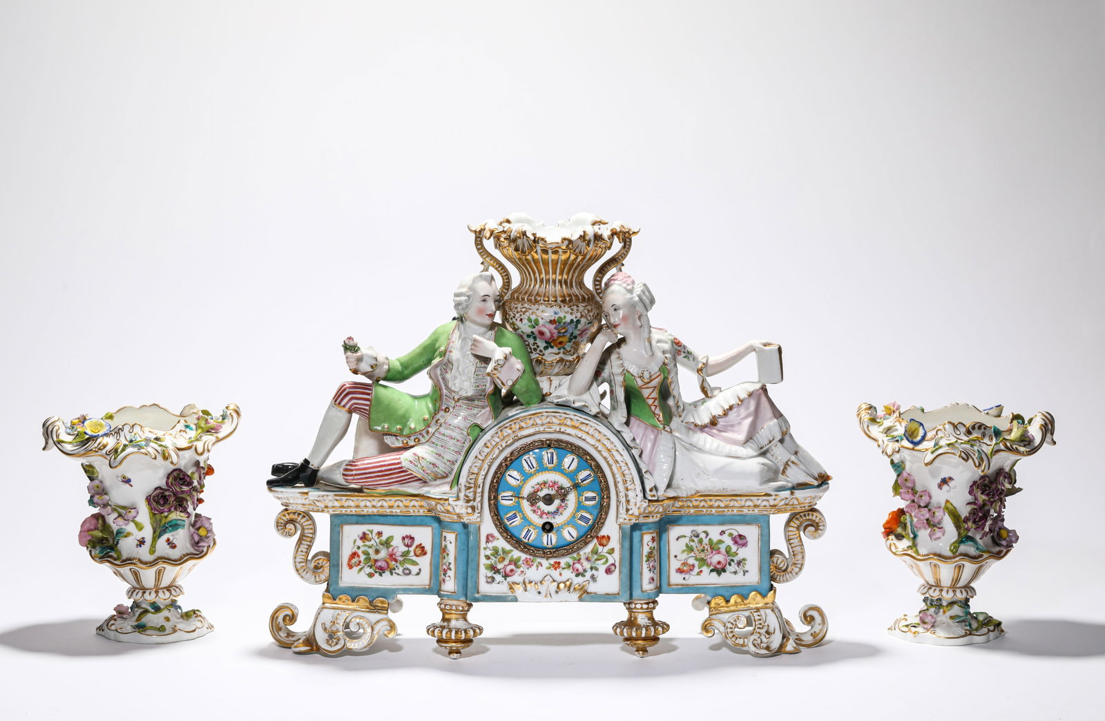 A GROUP OF PORCELAIN FIGURE MANTEL CLOCK AND FLOWER HOLDERS: A GROUP OF PORCELAIN FIGURE MANTEL CLOCK AND FLOWER HOLDERS Description: Dimensions: Length: 15.8 cm x Width: 13.2 cm x Height: 18.2 cm. Length: 43 cm x Width: 13 cm x Height: 33.5 cm. All