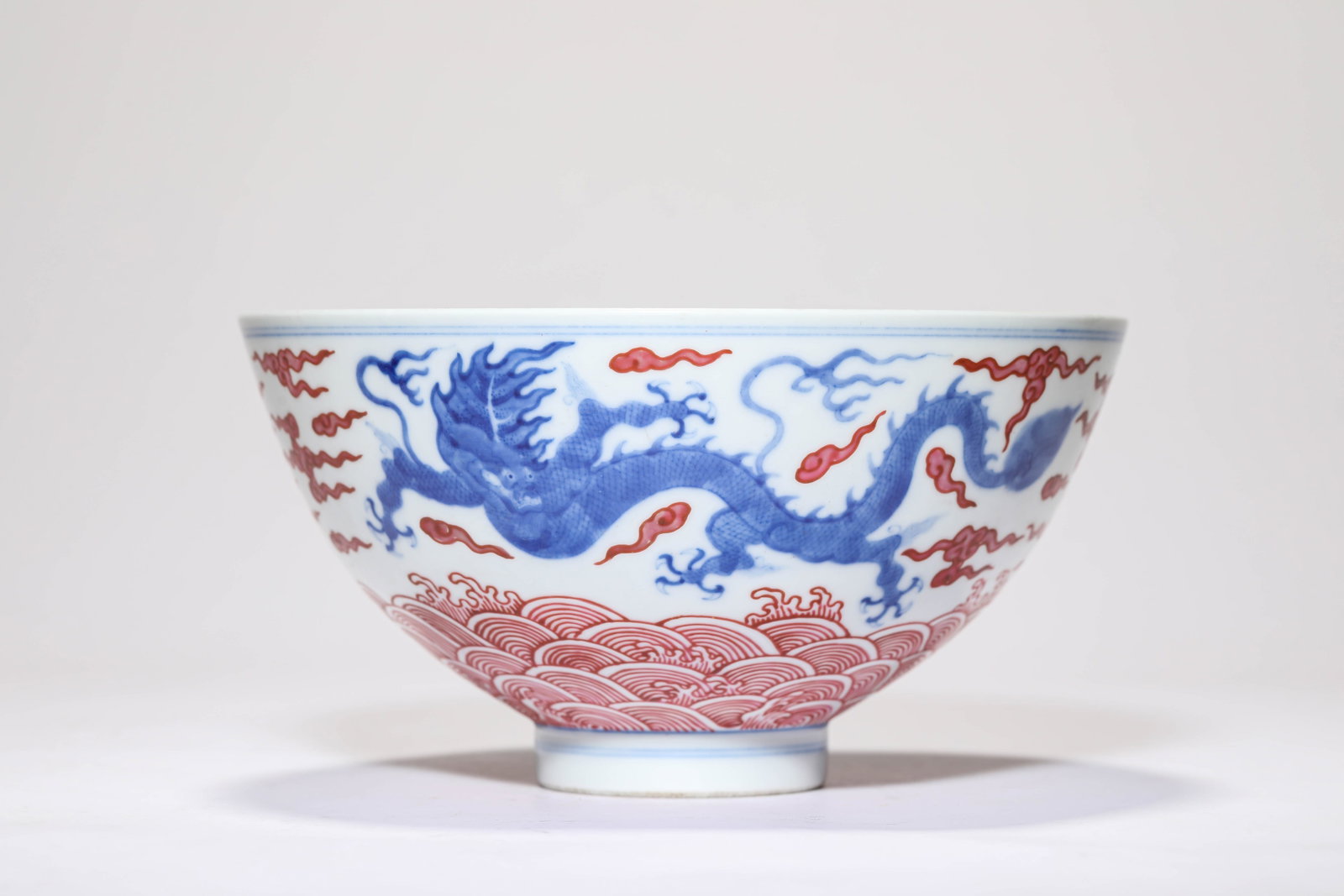A BLUE AND WHITE AND IRON-RED 'DRAGON AMIDST WAVES' BOWL: A BLUE AND WHITE AND IRON-RED 'DRAGON AMIDST WAVES' BOWL Description: Dimensions: Width: 19.4 cm x Height: 10.3 cm. All measurements are approximate.