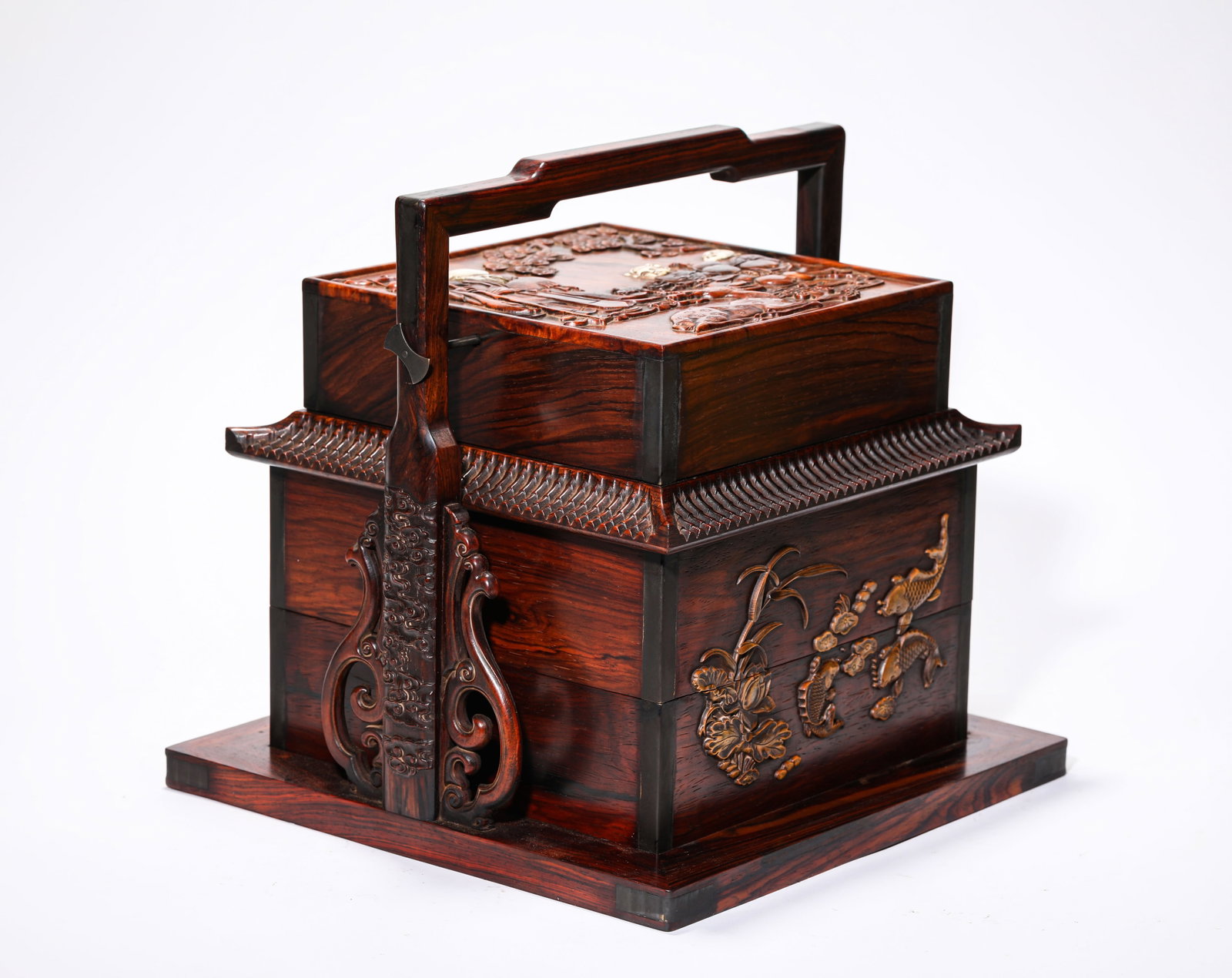 A WOOD 'CARVED BOY OFFERING LONGEVITY' TIERED BOX: A WOOD 'CARVED BOY OFFERING LONGEVITY' TIERED BOX Description: Dimensions: Width: 30.5 cm x Height: 30.3 cm. All measurements are approximate.
