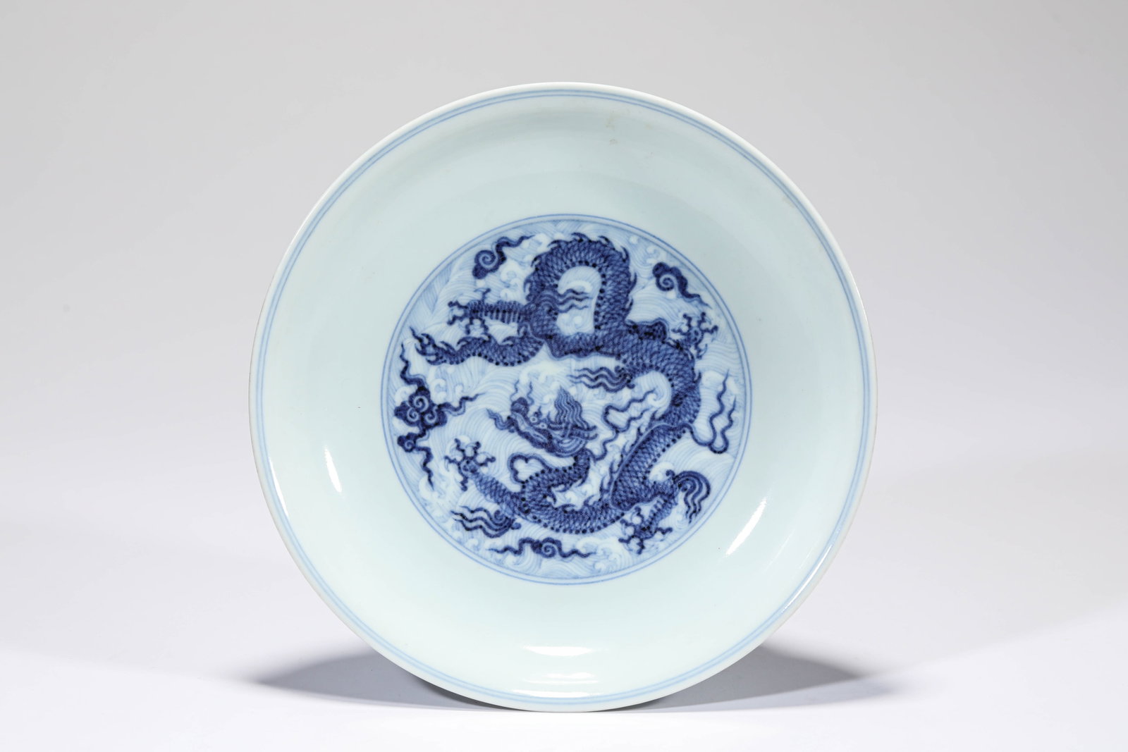 A BLUE AND WHITE 'DRAGON AND CLOUDS' DISH: A BLUE AND WHITE 'DRAGON AND CLOUDS' DISH Description: Dimensions: Width: 19.4 cm x Height: 4 cm. All measurements are approximate.