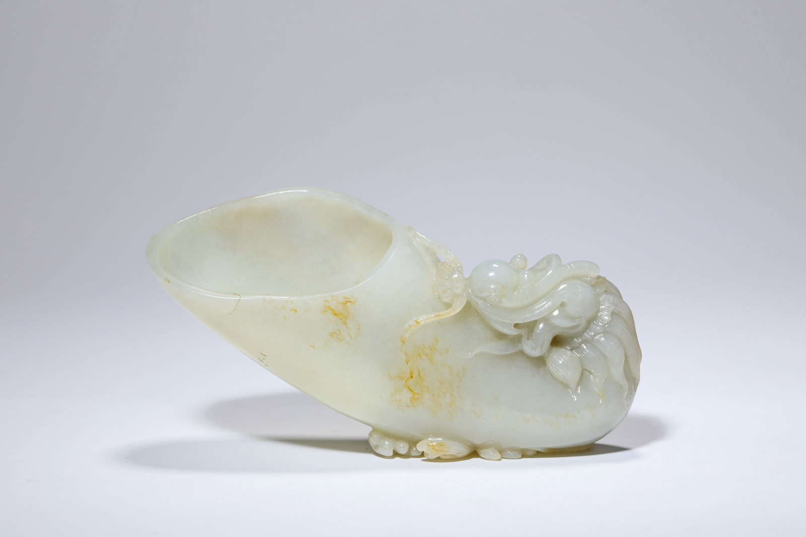 A JADE 'CARVED DRAGON-HEAD' CUP: A JADE 'CARVED DRAGON-HEAD' CUP Description: Dimensions: Length: 15.5 cm x Width: 4.8 cm x Height: 7.3 cm. All measurements are approximate.