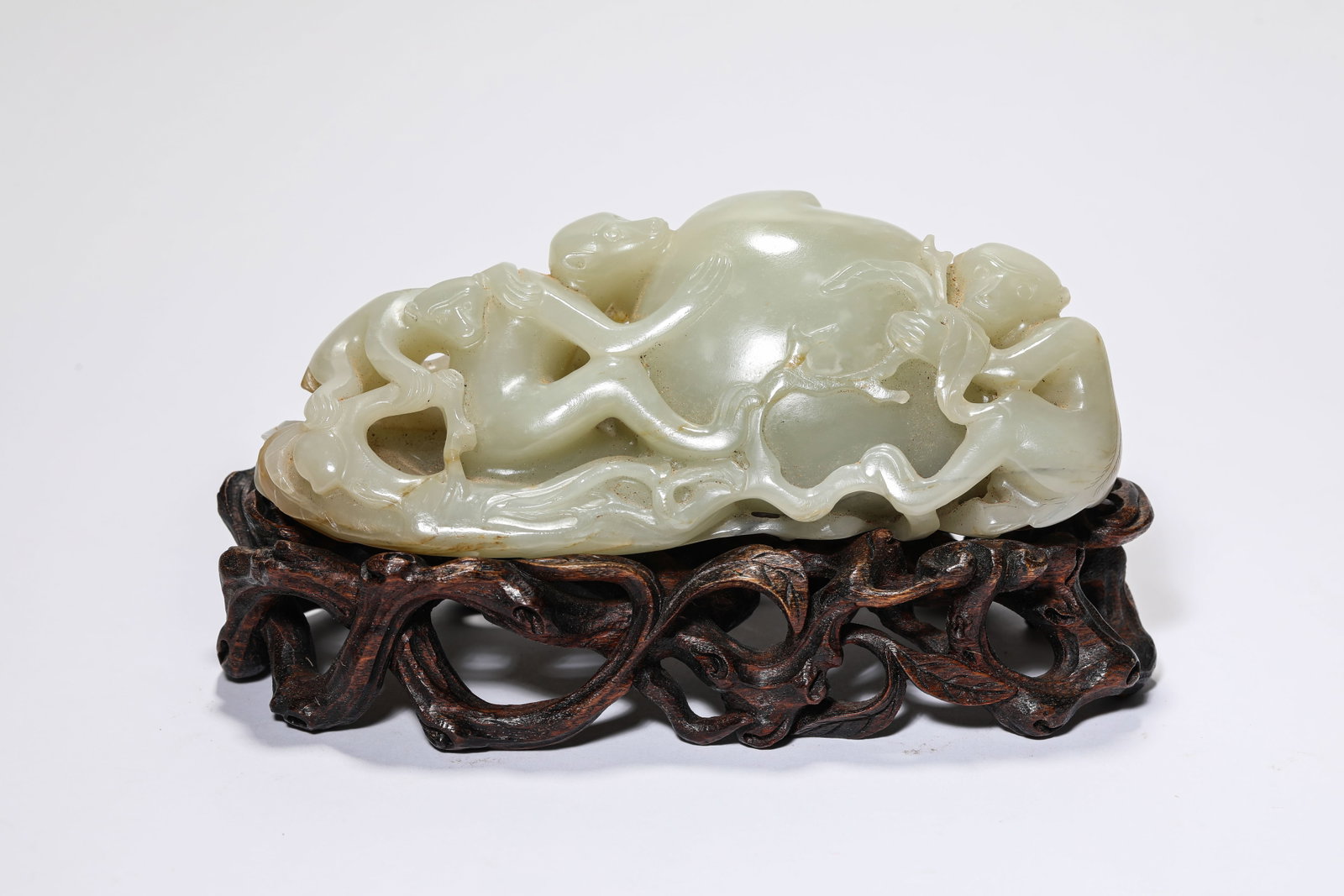 A JADE 'CARVED MONKEY OFFERING LONGEVITY' ORNAMENT: A JADE 'CARVED MONKEY OFFERING LONGEVITY' ORNAMENT Description: Dimensions: Length: 14.7 cm x Width: 6.7 cm x Height: 5.3 cm. All measurements are approximate.