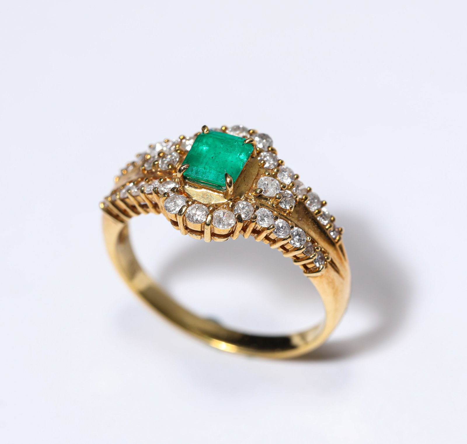 AN EMERALD AND GOLD RING: AN EMERALD AND GOLD RING Description: Dimensions: Weight: 3 g. Width: 1.6 cm. All measurements are approximate.