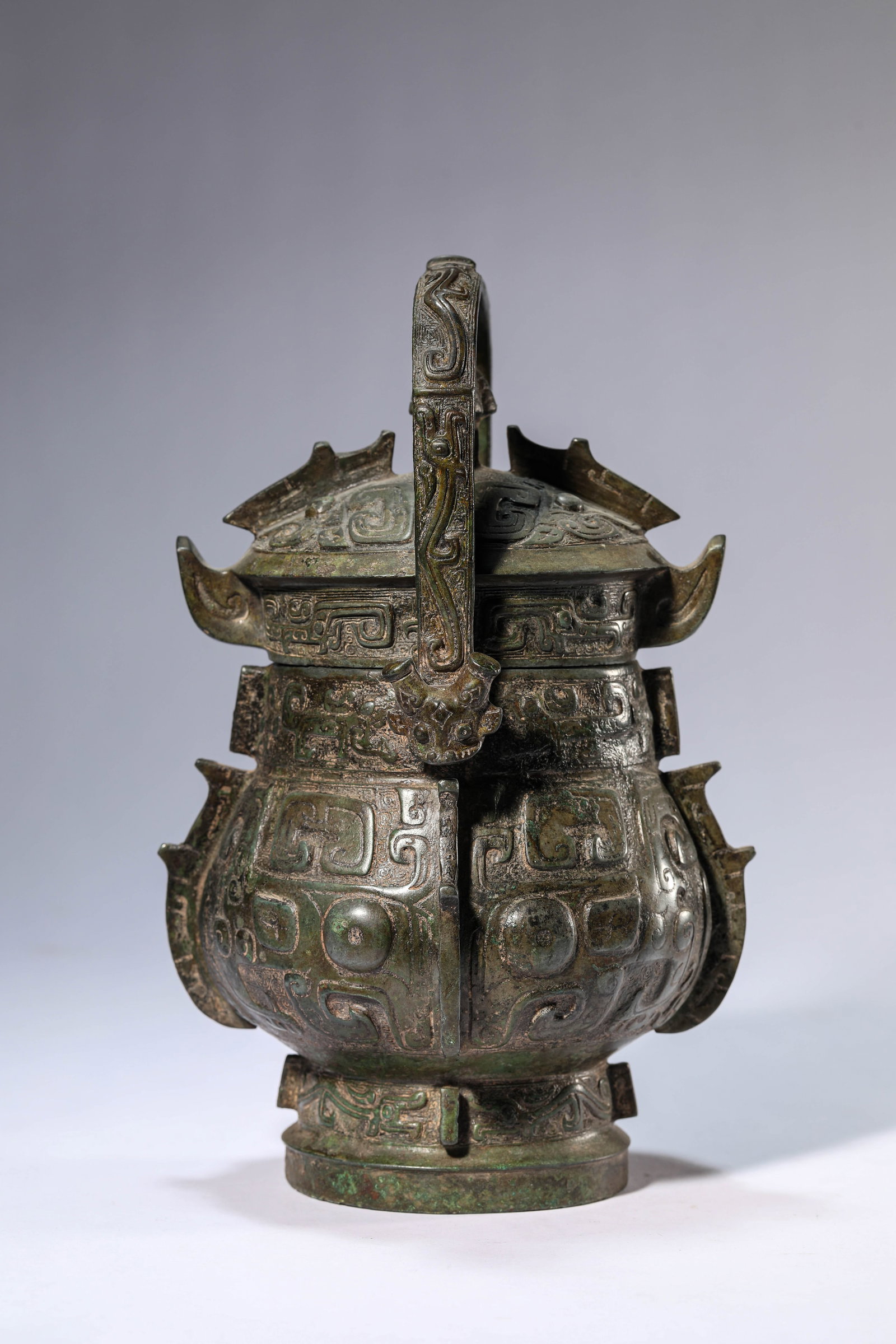 A BRONZE 'YOU' RITUAL WINE VESSEL: A BRONZE 'YOU' RITUAL WINE VESSEL Description: Dimensions: Weight: 2050 g. Length: 15.5 cm x Width: 14.1 cm x Height: 21.3 cm. All measurements are approximate.