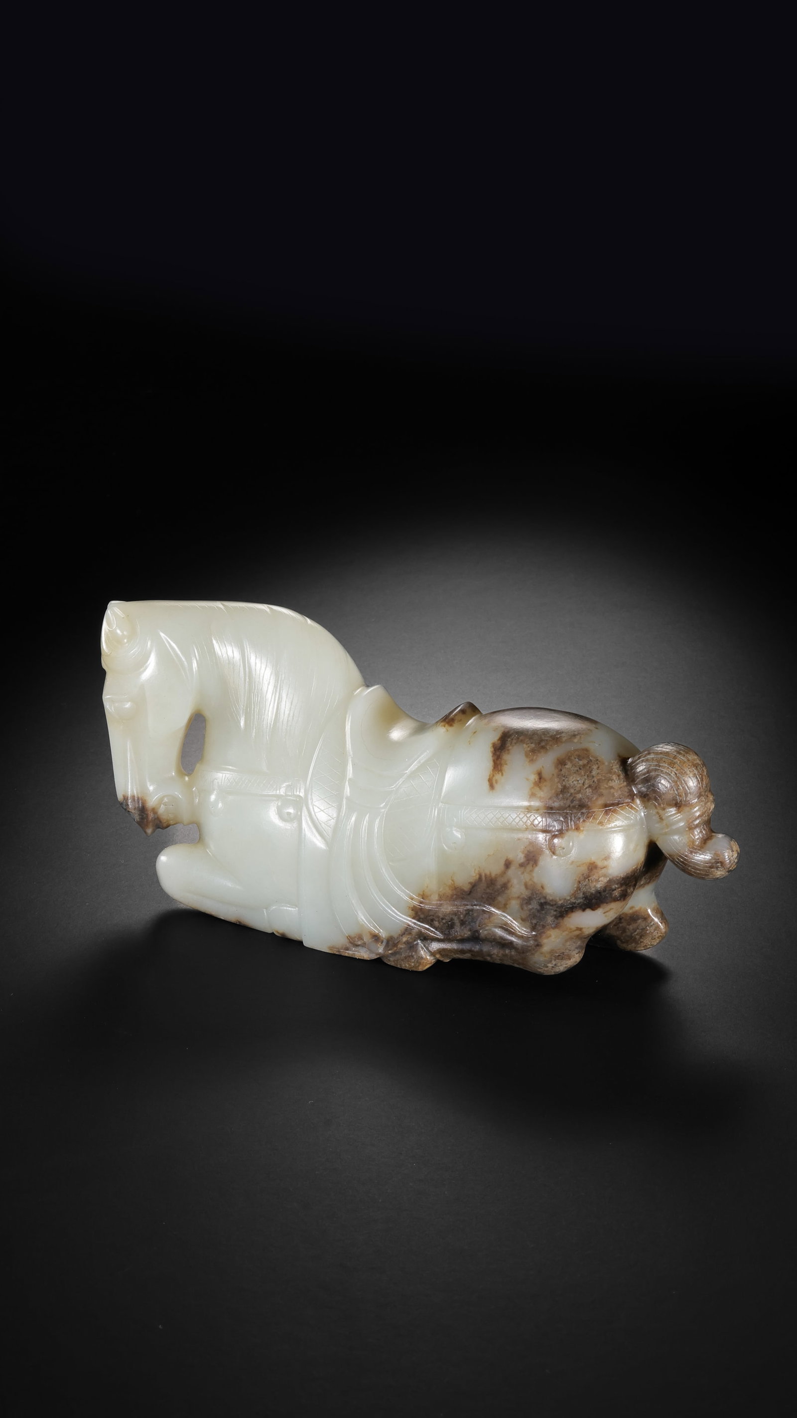 A BLACK AND WHITE JADE RECUMBENT HORSE: A BLACK AND WHITE JADE RECUMBENT HORSE Description: Dimensions: Width: 13.5 cm x Height: 6 cm. All measurements are approximate.