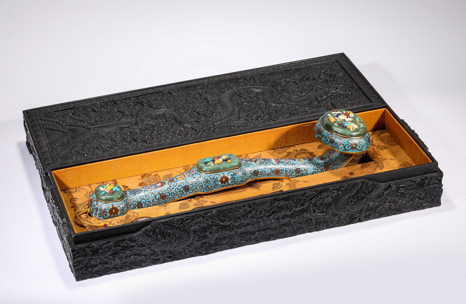 A CLOISONNE ENAMEL AND 'HUNDRED TREASURES'-INLAID RUYI SCEPTRE: A CLOISONNE ENAMEL AND 'HUNDRED TREASURES'-INLAID RUYI SCEPTRE Description: Dimensions: Weight: 1573 g. Length: 50 cm x Width: 11.8 cm x Height: 10.5 cm. All measurements are approximate.